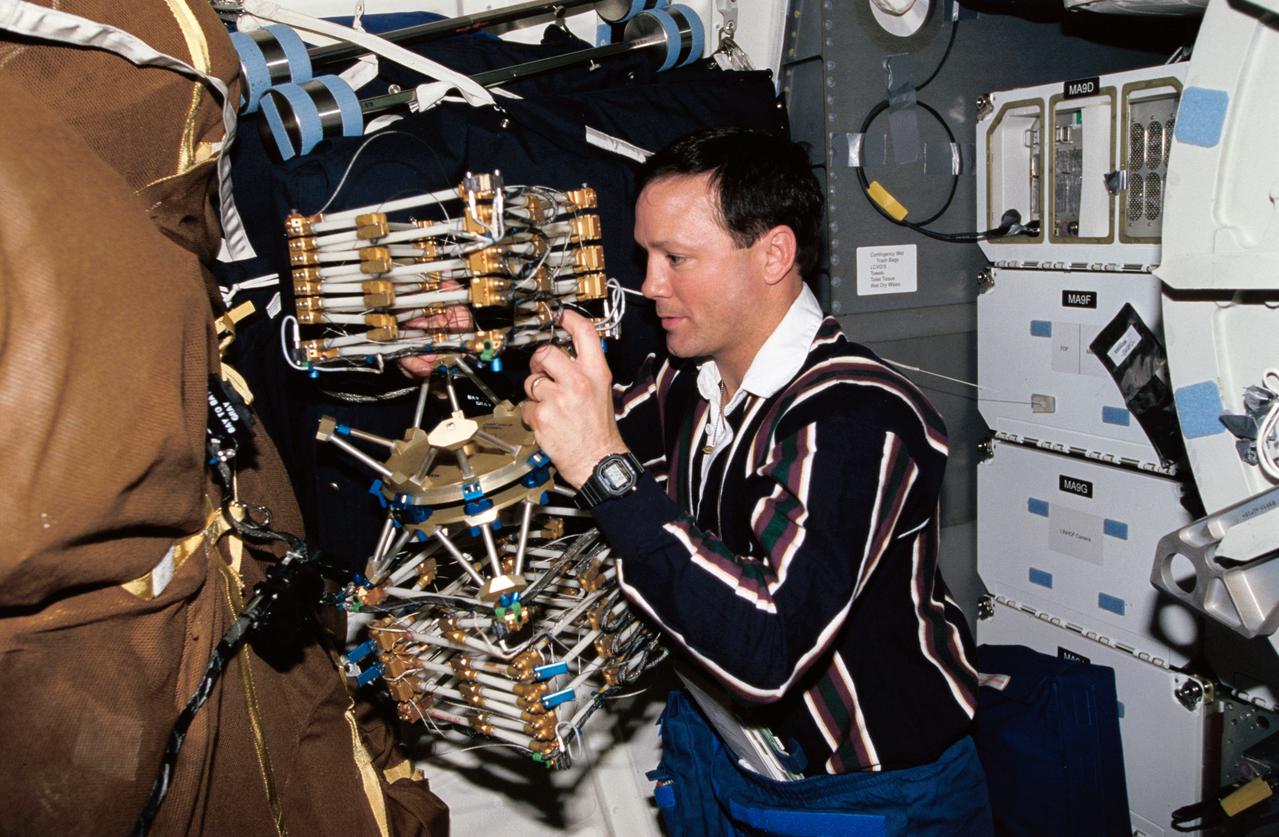STS062-52-025 (4-18 March 1994) --- Astronaut Pierre J. Thuot, mission specialist, works with the Middeck 0-Gravity Dynamics Experiment (MODE) aboard the earth-orbiting Space Shuttle Columbia.  The reusable test facility is designed to study the nonlinear, gravity-dependent behavior of two types of space hardware -- contained fluids and (as depicted here) large space structures -- planned for future spacecraft.