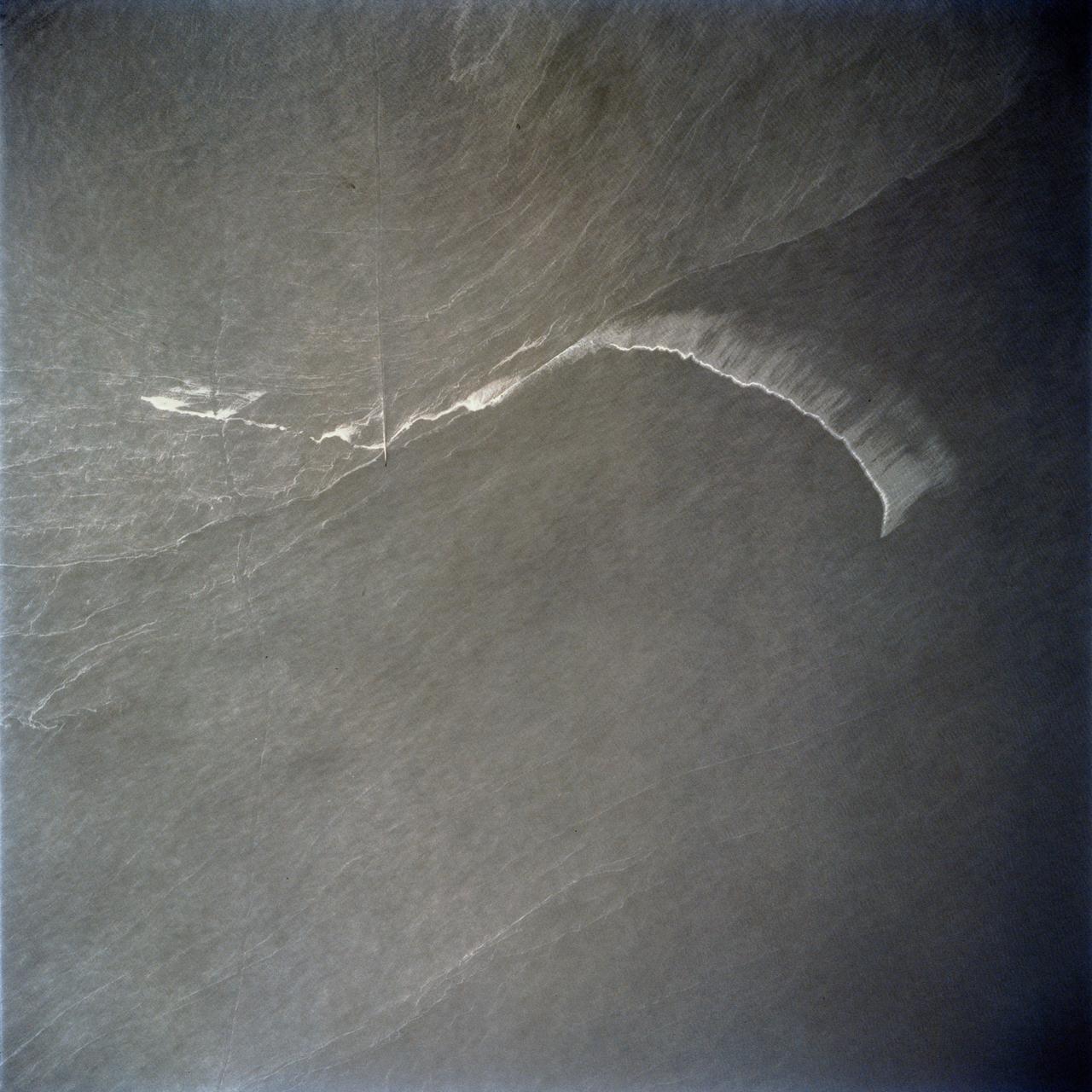 STS062-86-196 (4-18 March 1994) --- This photo depicts many of the types of ocean features seen when illuminated by sunglint.  These features include a shear line, bilge dump, currents and ship wakes.  Winds, currents and oils effect the smoothness of the surface of the water.  The oils smooth the water which reflect the sun more than the rougher surround water.  This is seen in the bright curved line which is a bilge dump of oily water from a ship.  The oils then start to take the form of the currents and in this case are also being blown by the surface winds.  The shear line is approximately 240 miles west of Bombay, India.  This shear line appears to be a result of two water masses, moving at slightly different speeds, having converged.  Ship wakes, such as those in the photo, which cross a shear line, often give us an indication of the relative strenght of a a shear.