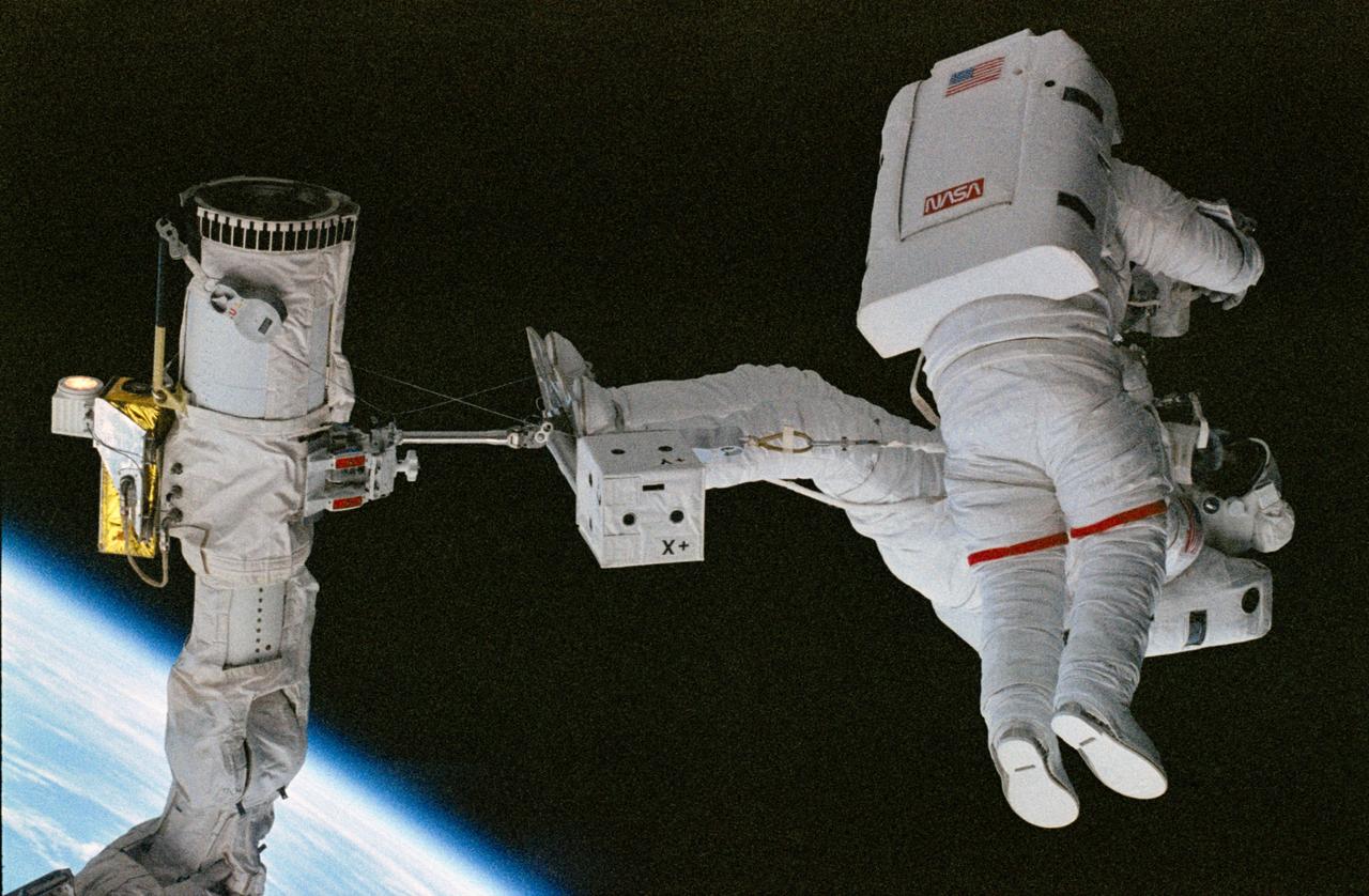 STS063-21-011 (9 Feb 1995) --- Astronaut Bernard A. Harris, Jr., payload commander, standing on a foot restraint attached to the Remote Manipulator System (RMS) arm carries astronaut C. Michael Foale, mission specialist, during their shared Extravehicular Activity (EVA) in the Space Shuttle Discovery's cargo bay.  This is one of 16 still photographs released by the NASA Johnson Space Center (JSC) Public Affairs Office (PAO) on February 14, 1995.  Others onboard the Discovery were astronauts James D. Wetherbee, mission commander; Eileen M. Collins, pilot; mission specialists Janice E. Voss and cosmonaut Vladimir G. Titov.