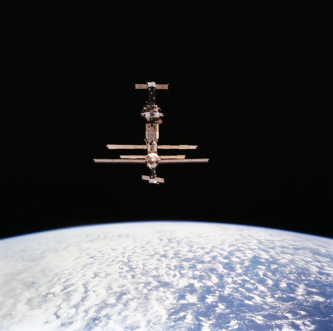 STS063-712-072 (6 Feb 1995) --- Russia's Mir Space Station over the blue and white Earth during initial approach for rendezvous operations with the Space Shuttle Discovery.  Docked at bottom (nearest portion where longest solar array panel is visible) is a Soyuz space vehicle.  On the opposite end is a Progress spacecraft.  This is one of 16 still photographs released by the NASA Johnson Space Center (JSC) Public Affairs Office (PAO) on February 14, 1995.  Onboard the Space Shuttle Discovery were astronauts James D. Wetherbee, mission commander; Eileen M. Collins, pilot; Bernard A. Harris Jr., payload commander; mission specialists C. Michael Foale, Janice E. Voss, and cosmonaut Vladimir G. Titov.