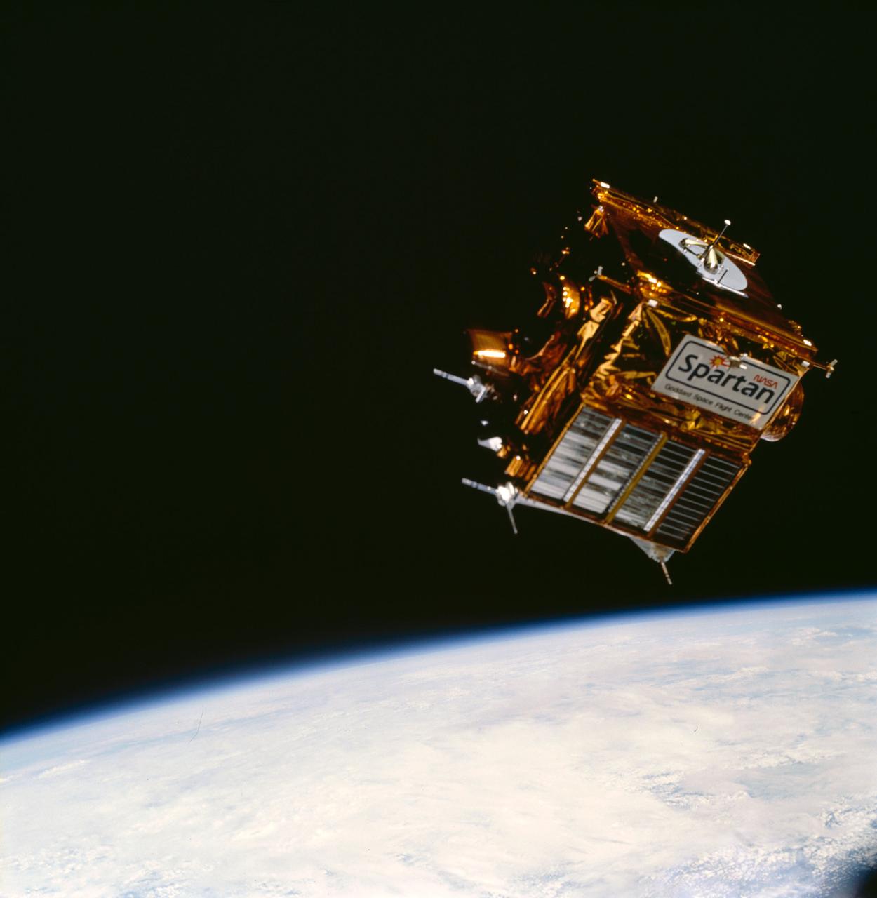 The blackness of space and part of Earth's horizon form the backdrop for this 70mm frame of the free-flying SPARTAN 204 mission. Carried into space by the STS-63 crewmembers, the satellite was later re-captured by the crew and used for maneuvering evaluations by the two space walkers, astronauts Bernard Harris and Michael Foale.