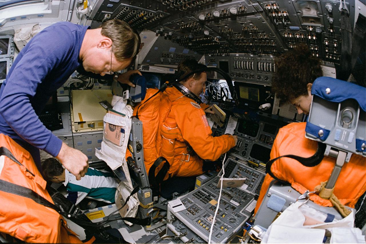 STS064-06-028 (9-20 Sept. 1994) --- On the space shuttle Discovery's flight deck, two thirds of the crew prepare for one of four hard efforts (in a two-day period) to de-orbit and complete the extended spaceflight.  Manning the commander's station and wearing one of the launch and entry suits is astronaut Richard N. Richards, STS-64 mission commander. At the pilot's station is astronaut Susan J. Helms, mission specialist. Astronaut L. Blaine Hammond, pilot, is at left foreground, and astronaut Carl J. Meade, mission specialist, is at left background in the hatch leading to the middeck. Photo credit: NASA or National Aeronautics and Space Administration