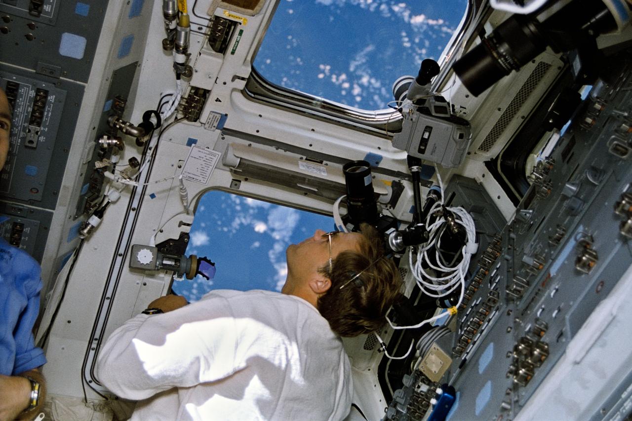 STS064-08-016 (9-20 Sept. 1994) --- Astronaut Mark C. Lee monitors the Lidar In-Space Technology Experiment (LITE) at work in the space shuttle Discovery's cargo bay. The mission specialist is surrounded by cameras which were used by the six NASA astronauts onboard for the almost 11-day mission. Near Lee's head is a 100mm lens which he used to collect data on a myriad of cloud formations  which he observed on Earth, 130 nautical miles away. Photo credit: NASA or National Aeronautics and Space Administration     EDITOR'S NOTE: In uncropped versions of this picture, astronaut Carl J. Meade is partially in frame at left.