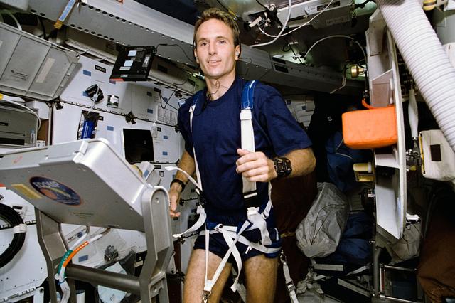 Astronaut Jerry Linenger works out on treadmill device on middeck
