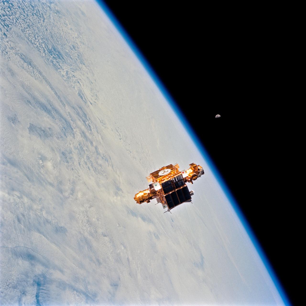 STS064-74-052 (9-20 Sept. 1994) --- Astronauts onboard the space shuttle Discovery used a 70mm camera to capture this photograph of the retrieval operations with the Shuttle Pointed Autonomous Research Tool for Astronomy 201 (SPARTAN 201). A gibbous moon can be seen in the background. Photo credit: NASA or National Aeronautics and Space Administration