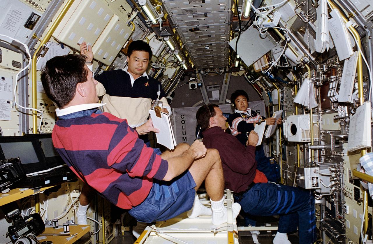 STS065-05-037 (8-23 July 1994) --- In the science module aboard the Space Shuttle Columbia, four members of the crew busy themselves with experiments in support of the second International Microgravity Laboratory (IML-2) mission.  Left to right are Donald A. Thomas and Leroy Chiao, both mission specialists; Richard J. Hieb, payload commander, and Dr. Chiaki Mukai of NASDA, payload specialist.