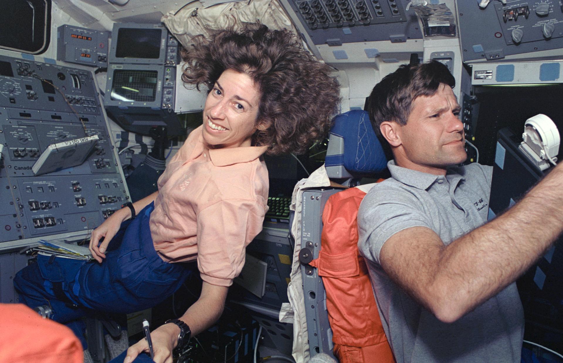 Ellen Ochoa and Don McMonagle sitting at their stations in Atlantis' aft flight deck.