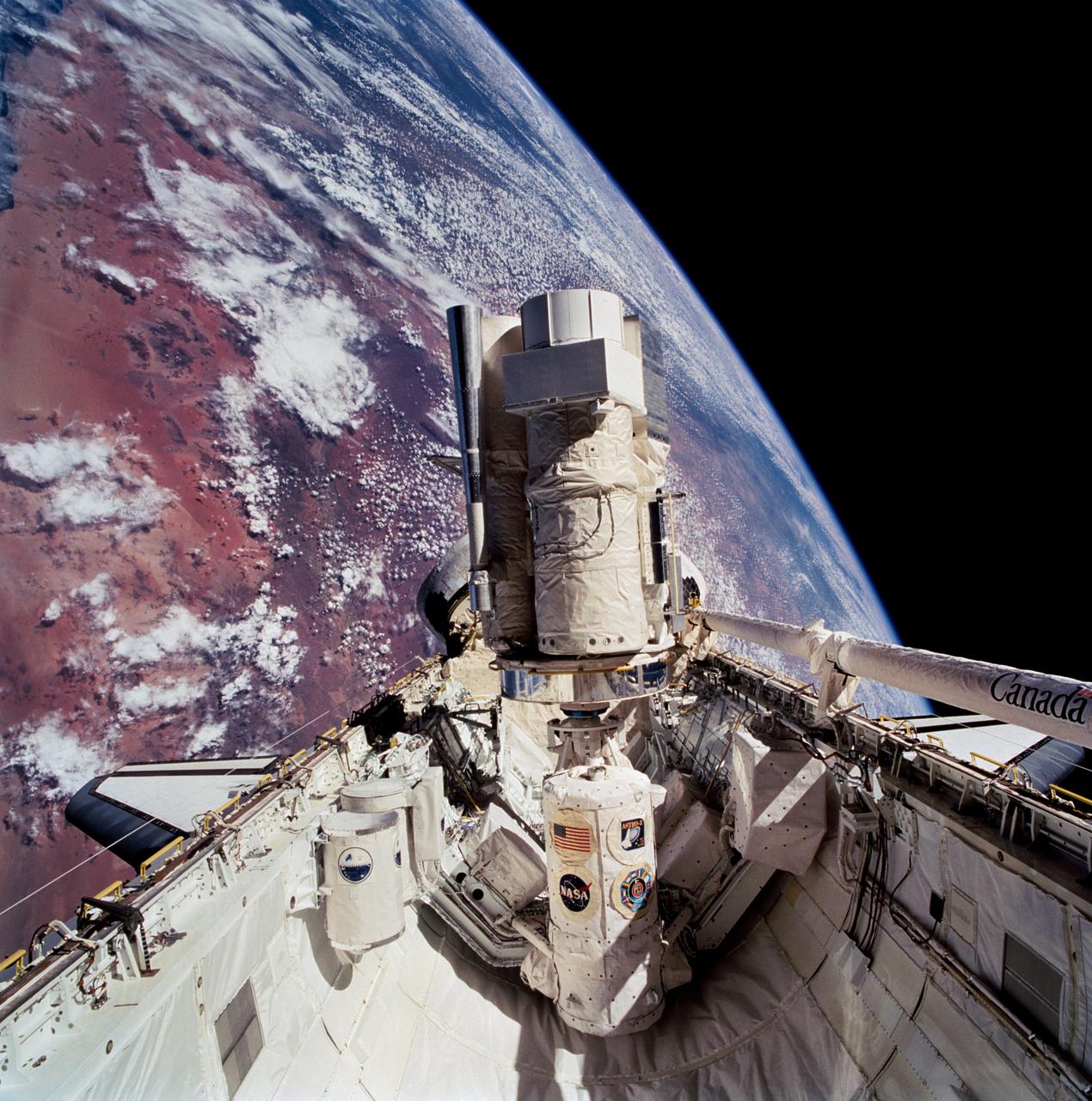 STS067-713-072 (2-18 March 1995) --- This 70mm cargo bay scene, backdropped against a desert area of Namibia, typifies the view that daily greeted the Astro-2 crew members during their almost 17-days aboard the Space Shuttle Endeavour.  Positioned on the Spacelab pallet amidst other hardware, the Astro-2 payload is in its operational mode.  Visible here are the Instrument Pointing System (IPS), Hopkins Ultraviolet Telescope (HUT), Star Tracker (ST), Ultraviolet Imaging Telescope (UIT), Wisconsin Ultraviolet Photo-Polarimeter Experiment (WUPPE), and Integrated Radiator System (IRS).  At this angle, the Optical Sensor Package (OPS) is not seen.  The Igloo, which supports the package of experiments, is in center foreground.  Two Get-Away Special (GAS) canisters are in lower left foreground.  The Extended Duration Orbiter (EDO) pallet, located aft of the cargo bay, is obscured by the Astro-2 payload.  The Endeavour was 190 nautical miles above Earth.