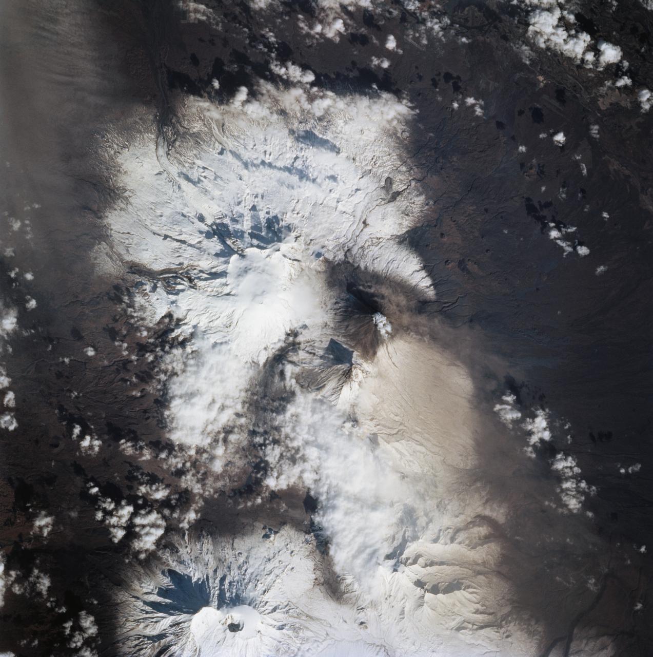 STS068-273-060 (4 October 1994) ---  Astronauts aboard the Space Shuttle Endeavour recorded this follow-up 70mm frame of the Kliuchevskoi volcano on the Kamchatka Peninsula in Russia. The volcano was near its peak on launch day, five days earlier, but only a small steam plume was rising from the summit in this Day 5 photo. Tendrils of ash are airborne on the northern flank of the volcano. Scientists feel that the source of these plumes is from a flow down the mountain's northern flank. The entire summit region is covered in ash. As various members of the six-person crew were using handheld cameras to record the various stages of the volcano, hardware in Endeavour's cargo bay was taking radar data of the event in support of the Space Radar Laboratory (SRL-2) mission.