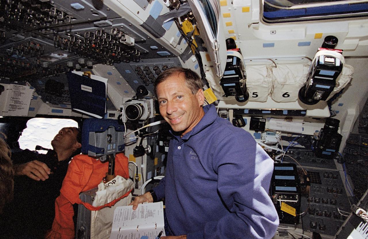 STS069-363-010 (7-18 September 1995) --- Astronaut Kenneth D. Cockrell, pilot, looks over a logbook on Space Shuttle Endeavour&#0146;s flight deck during rendezvous operations involving one of two temporarily free-flying craft.  Astronaut James H. Newman (background), mission specialist, eyeballs the target. Endeavour, with a five-member crew, launched on September 7, 1995, from the Kennedy Space Center (KSC).  The multifaceted mission ended September 18, 1995, with a successful landing on Runway 33 at KSC.