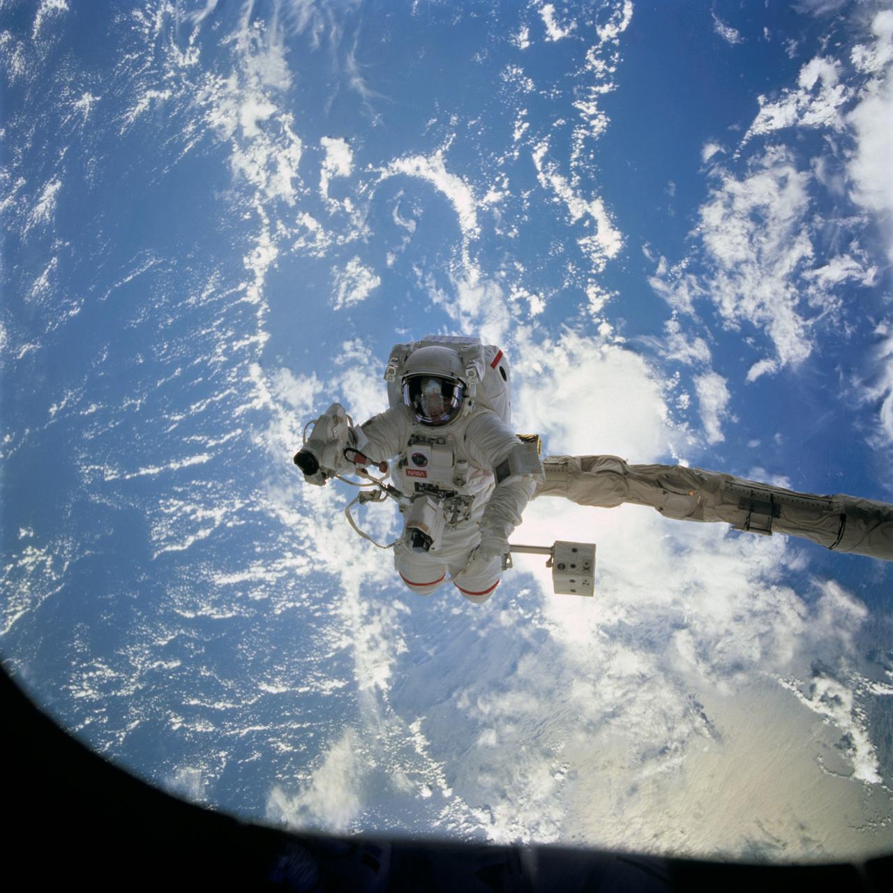 STS069-715-086 (16 September 1995) --- Astronaut James S. Voss, payload commander, is pictured during the September 16, 1995, Extravehicular Activity (EVA) which was conducted in and around Space Shuttle Endeavour's cargo bay. Voss, whose visor reflects Endeavour's forward section, was standing on a mobile foot restraint attached to the arm of the Remote Manipulator System (RMS). Voss is holding a camera, which he used to record some of the EVA, as well as snapshots of Endeavour's cabin.  Evaluations for Space Station-era tools and various elements of the space suits were performed by Voss and his space walking crewmate, astronaut Michael L. Gernhardt, mission specialist.