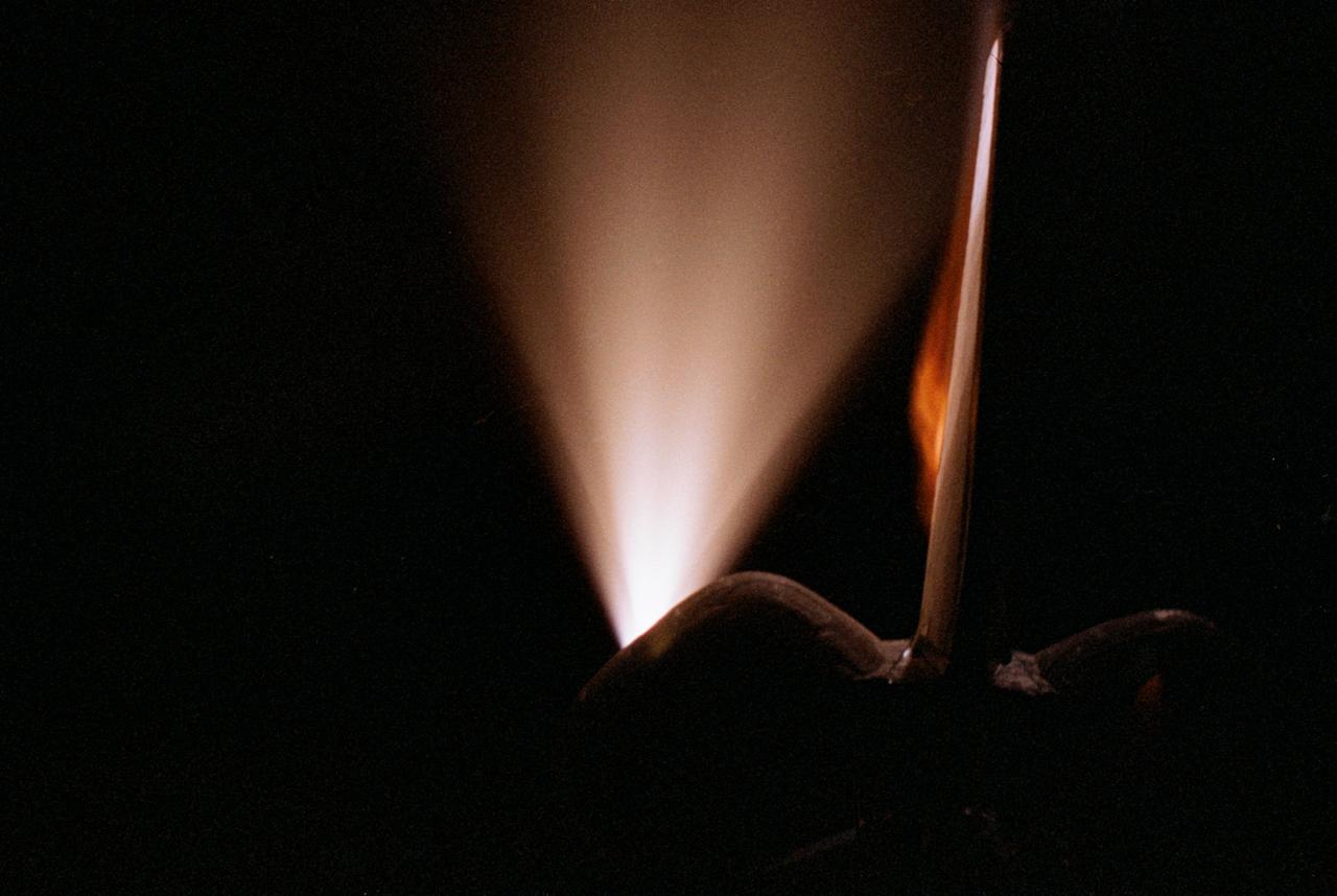 STS070-386-027 (13-22 JULY 1995) --- High-speed film provided this close-up view of the Space Shuttle Discovery’s aft, featuring the ignition of one of the primary thrusters.  Note the impact of the firing on the starboard side of the vertical stabilizer.  Crew members told a August 11, 1995, gathering of Johnson Space Center (JSC) employees that the Window Experiment (WINDEX) paid close attention to surface glow, jet plumes, water dumps, aurora and airglow.  The data collection is part of an effort to avoid misinterpretation of measurements of Earth, the solar system and starts taken from satellites in low Earth-orbits and prevent damage to sensitive systems and solar arrays during rendezvous and docking.  Such firings of the thrusters increase local densities of gases in the atmosphere dramatically and introduce non-natural elements that react with the atmosphere dramatically and spacecraft systems enveloped by the thruster plume.  WINDEX recorded phenomena associated with thruster start-up and shut-down transients and observed the effect of the transients on Shuttle glow phenomenon.