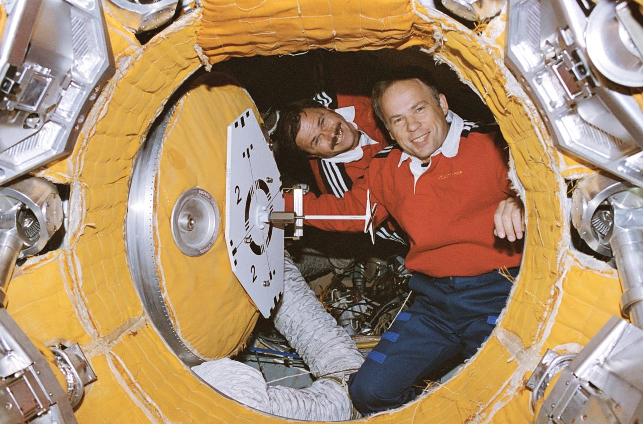 STS071-117-032 (4 July 1995) --- In the docking vestibule of Russia's Mir Space Station, cosmonauts Anatoly Y. Solovyev, Mir-19 commander, and Nikolai M. Budarin, Mir-19 flight engineer, smile at the departing Space Shuttle Atlantis STS-71 crew prior to hatch closing.  Later, the two manned the Soyuz vehicle as it was temporarily moved from the Mir complex for Atlantis' undocking. 