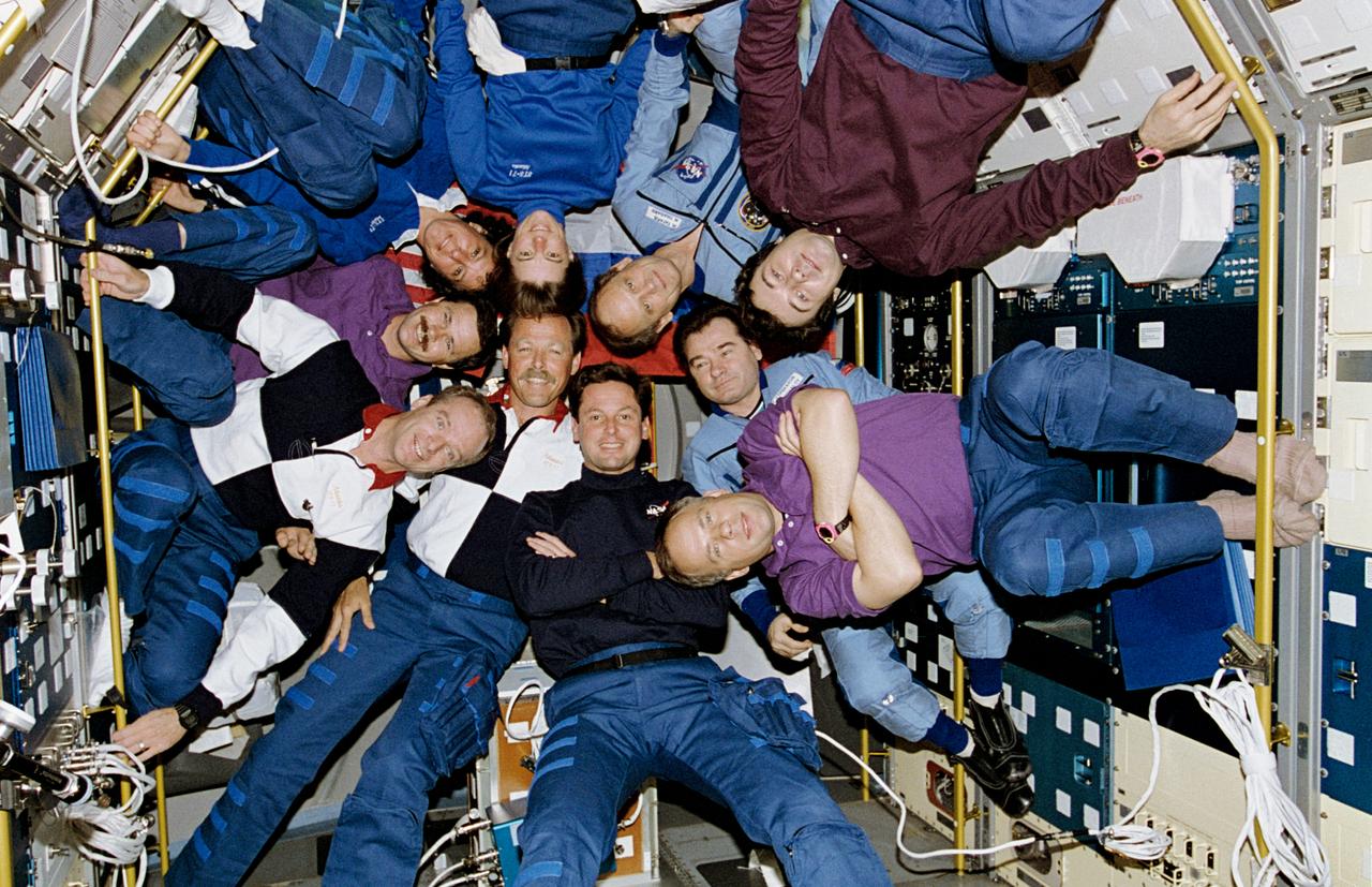 STS071-122-013 (27 June-7 July 1995) --- Inside the space shuttle Atlantis' Spacelab Science Module, the crewmembers of STS-71, Mir-18 and Mir-19 pose for the traditional inflight portrait. For individual identification, hold picture vertically with socked feet of Anatoly Y. Solovyev at bottom center. Clockwise from Solovyev are astronauts Gregory J. Harbaugh, Robert L. Gibson, Charles J. Precourt, Nikolai M. Budarin, Ellen S. Baker, Bonnie J. Dunbar, Norman E. Thagard, and cosmonauts Gennadiy M. Strekalov (at angle) and Vladimir N. Dezhurov.
