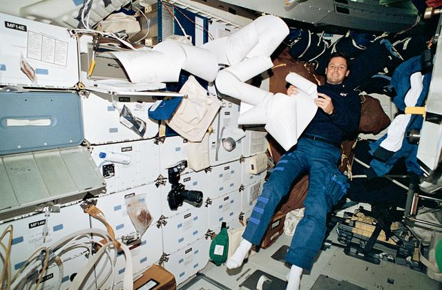 NASA image: Astronaut Harbaugh on middeck with messages from TIPS