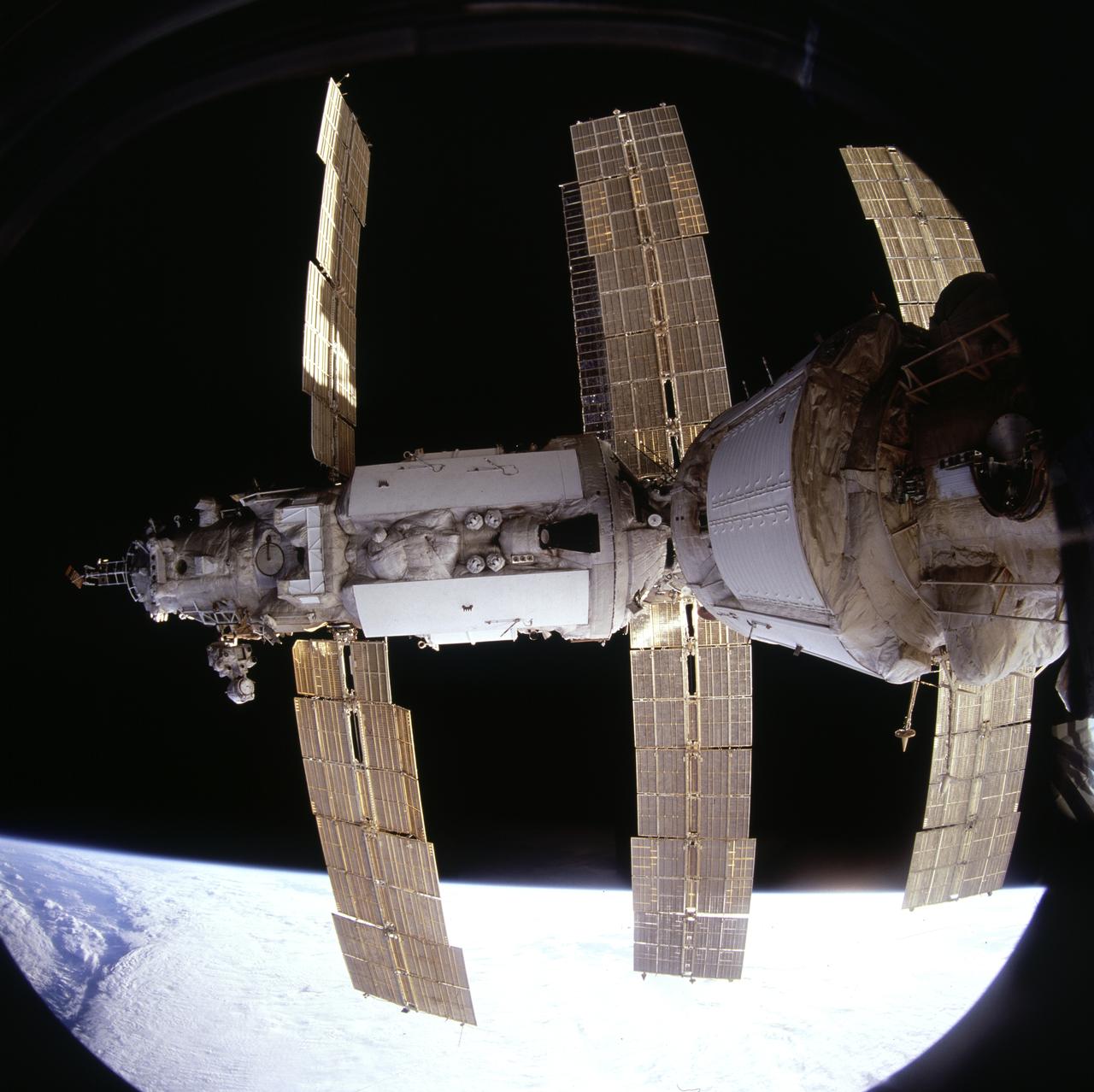 STS071-701-089 (27 June-7 July 1995) --- This view of many of the adjoined components of Russia's Mir Space Station was provided by a crew member aiming a hand-held Hasselblad camera through an overhead window on the space shuttle Atlantis' aft flight deck. During the week in which the Atlantis and Mir were docked, six astronauts and four cosmonauts stayed busy in several different areas. Most of the time was spent in the Spacelab Science Module in Atlantis' cargo bay.