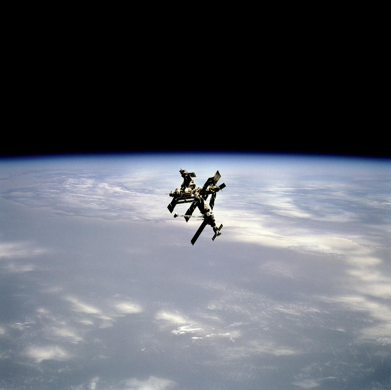 STS071-744-030 (29 June 1995) --- Russia's Mir Space Station is backdropped against blue and white Earth near its horizon, as photographed from the approaching space shuttle Atlantis on June 29, 1995.  Five NASA astronauts and two cosmonauts were onboard Atlantis as it approached the Mir, which housed the three-member Mir-18 crew.