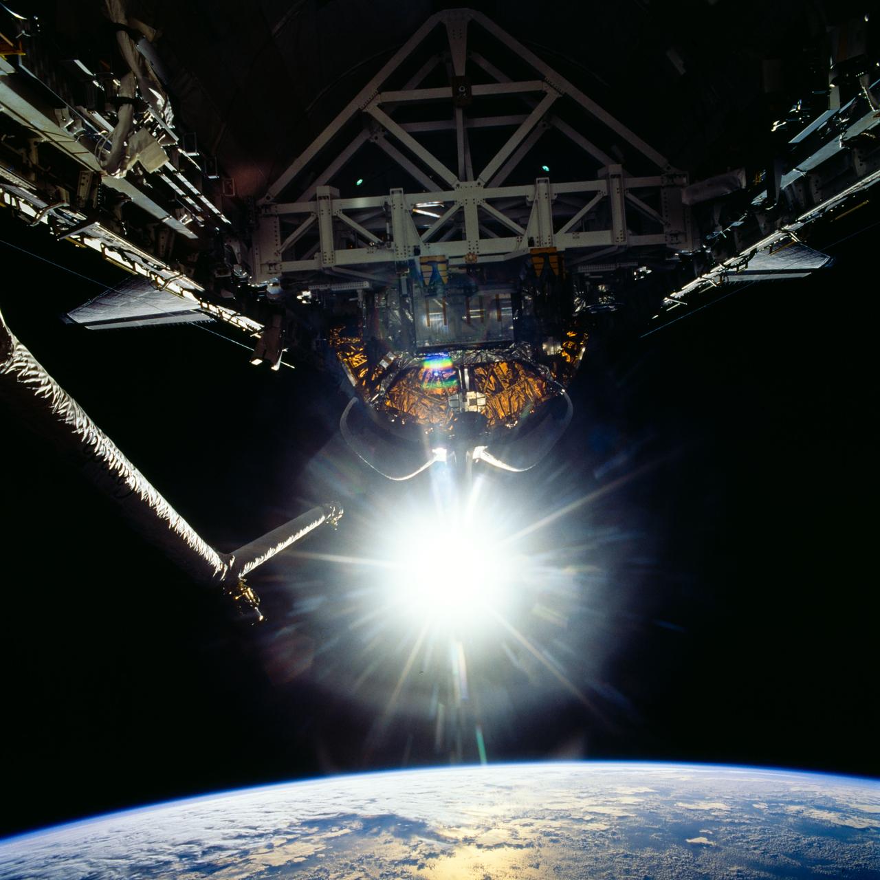 STS072-726-085 (11-20 Jan. 1996) --- The crew members captured this 70mm view of the Space Shuttle Endeavour’s cargo bay, with the reflection of sunglint over Earth’s horizon. The Canadian-built Remote Manipulator System (RMS) arm, with two television cameras affixed, is at frame right. The crew earlier had retrieved the Japanese Space Flyer (SFU) and berthed in the aft cargo bay, along with the Office of Aeronautics and Space Technology (OAST) Flyer satellite.