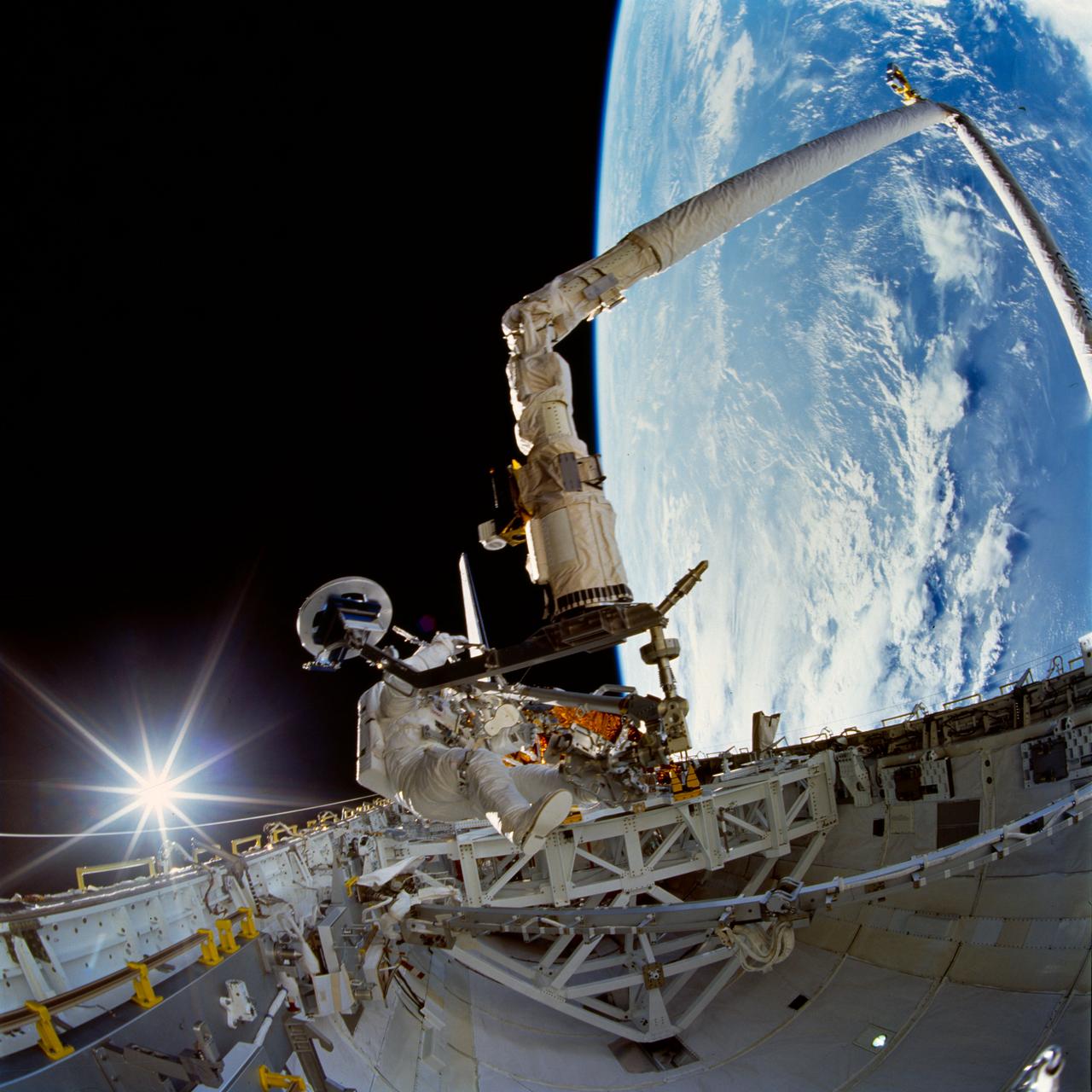 STS072-742-004 (15 Jan. 1996) --- Astronaut Daniel T. Barry, STS-72 mission specialist, tests a Temporary Equipment Restraint Aid (TERA) in the cargo bay of the Earth-orbiting space shuttle Endeavour. A reflection of the sun’s rays beam off Endeavour’s aft flight deck window in the “fish-eye” image. Barry was joined by astronaut Leroy Chiao for this first of two extravehicular activities (EVA) on the mission. A good part of the EVA was spent evaluating EVA hardware for future scheduled missions. Astronauts Chiao and Winston E. Scott participated in the second EVA two days later. Photo credit: NASA