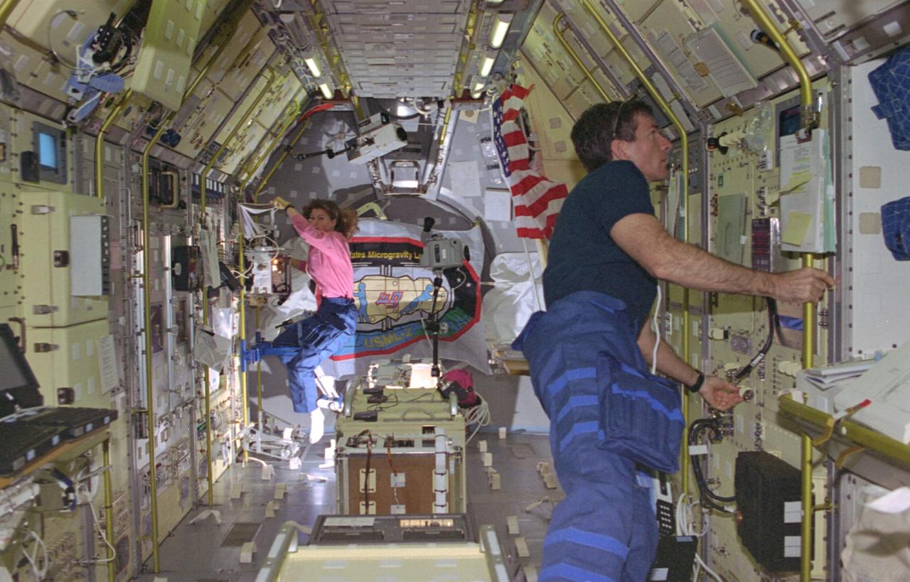 STS073-103-019 (20 October-5 November 1995) --- This wide view gives an overall perspective of the working environment of five astronauts and two guest researchers for 16 days in Earth-orbit.  At work in support of the U.S. Microgravity Laboratory (USML-2) mission in this particular scene are astronaut Catherine G. Coleman, who busies herself at the glovebox, and payload specialist Fred W. Leslie, monitoring the Surface-Tension-Driven Convection Experiment (STDCE).