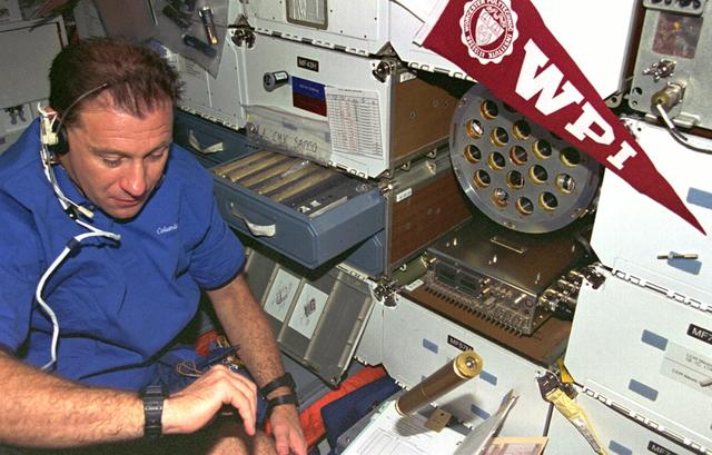 STS073-353-010 (20 October - 5 November 1995) --- Payload specialist Albert Sacco Jr. checks out the Zeolite Crystal Growth (ZCG) on the middeck of the Earth-orbiting Space Shuttle Columbia.  ZCG evaluated Zeolite crystallization and growth in the microgravity environment aboard Columbia in order to achieve high yields of large, nearly perfect crystals in space.  Zeolites are complex arrangements of silica and alumina that occur naturally as well as synthetically.