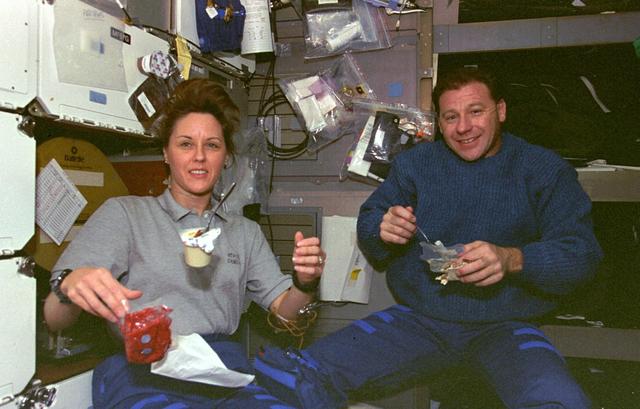 STS073-356-024 (20 October - 5 November 1995) --- Payload specialist Albert Sacco Jr. joins astronaut Kathryn C. Thornton, payload commander, for mealtime on the middeck of the Earth-orbiting Space Shuttle Columbia.  Thornton is about to open a packet of strawberries, while a can of vanilla pudding floats before her.  Sacco is about to grab a spoonful of rice pilaf while holding a peanut butter and jelly sandwich on a tortilla.  The two were joined by five other crewmembers in support of 16-days' in-space research in support of the United States Microgravity Laboratory (USML-2) mission.