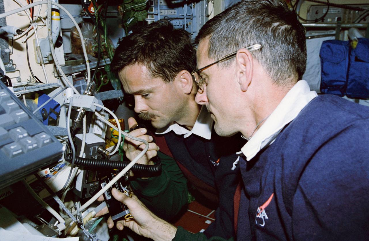 STS074-324-030 (12-20 Nov 1995) --- Astronauts Chris A. Hadfield (left) and William S. McArthur, Jr. check out the Shuttle Amateur Radio Experiment (SAREX) onboard Russia?s Mir Space Station.  With five NASA astronauts aboard, the flight of the Space Shuttle Atlantis began with a November 12, 1995, launch from Kennedy Space Center (KSC) and ended with landing there on November 20, 1995.  The STS-74 crew members were astronauts Kenneth D. Cameron, mission commander; James D. Halsell, Jr., pilot; McArthur, Jerry L. Ross and Canadian astronaut Hadfield, all mission specialists.  On November 15, 1995, the Space Shuttle Atlantis docked with the Mir Space Station, on which the STS-74 astronauts joined the Mir-20 crew.  The Mir-20 crew is composed of cosmonauts Yuriy P. Gidzenko, commander; and Sergei V. Avdeyev, flight engineer; along with the European Space Agency?s (ESA) Thomas Reiter, cosmonaut researcher.  Joint activities on the Mir Space Station and the Space Shuttle Atlantis ended November 18, 1995, when the two spacecraft separated.