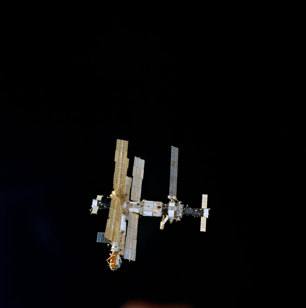 STS074-716-044 (18 Nov 1995) --- With the darkness of space providing the backdrop, this is the Russia?s Mir Space Station as seen from the Space Shuttle Atlantis, not long after the two spacecraft began their relative separation on November 18, 1995.  The new Docking Module (DM), delivered by Atlantis over three days earlier, is easily identified in the 70mm frame.  With five NASA astronauts aboard the Space Shuttle Atlantis, the flight began with a November 12, 1995, launch from Kennedy Space Center (KSC) and ended with landing there on November 20, 1995.  The STS-74 crew members were astronauts Kenneth D. Cameron, mission commander; James D. Halsell Jr., pilot; William S. McArthur Jr., Jerry L. Ross and Canadian astronaut Chris A. Hadfield, all mission specialists.  On November 15, 1995, the Space Shuttle Atlantis docked with the Mir Space Station, on which the STS-74 astronauts joined the Mir-20 crew.  The Mir-20 crew is composed of cosmonauts Yuriy P. Gidzenko, commander; and Sergei V. Avdeyev, flight engineer; along with the European Space Agency?s (ESA) Thomas Reiter, cosmonaut researcher.  Joint activities on the Mir Space Station and the Space Shuttle Atlantis ended November 18, 1995, when the two spacecraft separated.