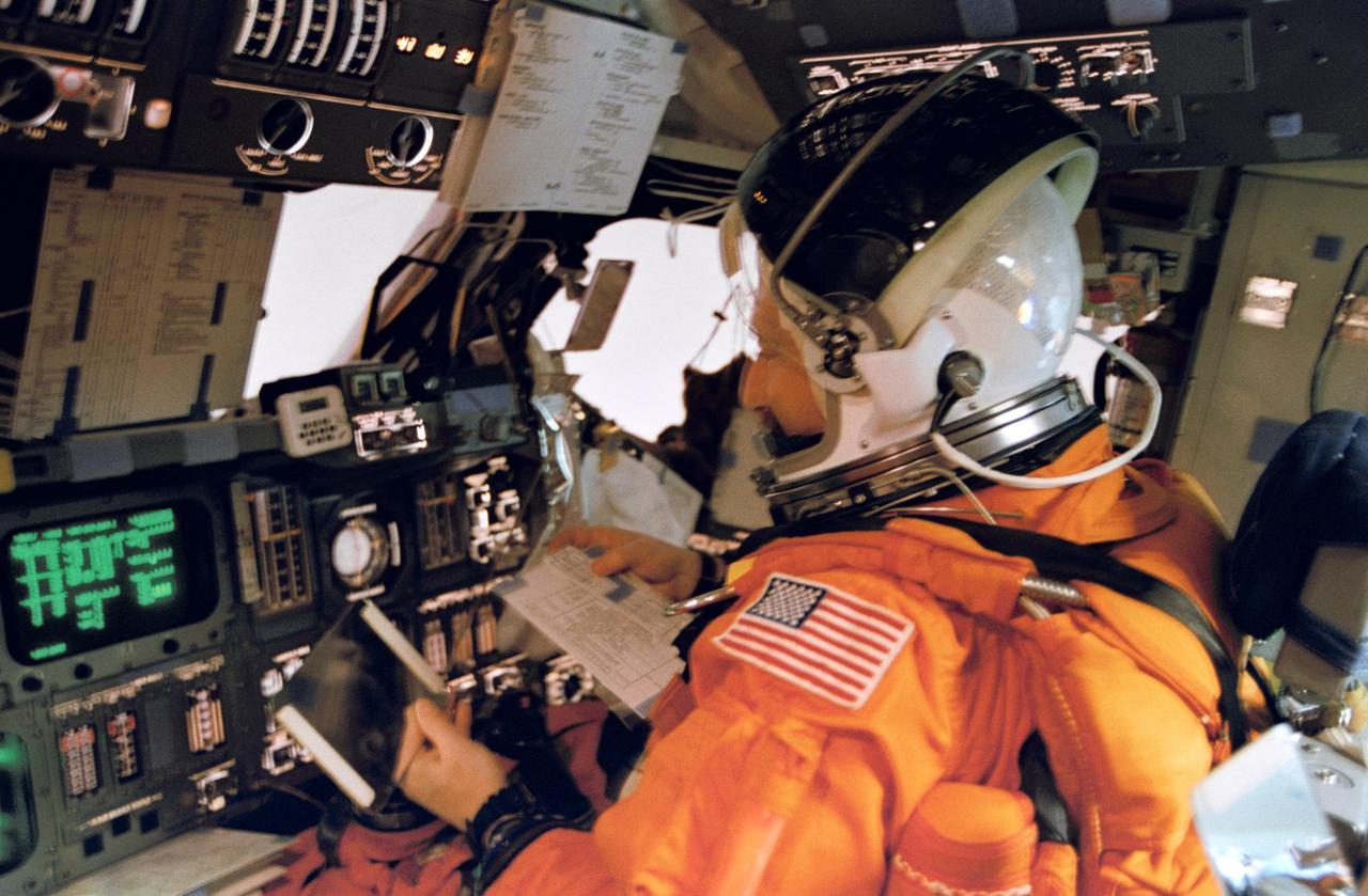 STS075-322-012 (9 March 1996) --- Seated at the pilot's station, astronaut Scott J. Horowitz uses a mirror to monitor the vertical stabilizer and the aft cargo bay area during the entry phase of the flight. Horowitz, pilot, joined four other astronauts and an international payload specialist for 16 days of scientific research in Earth-orbit.