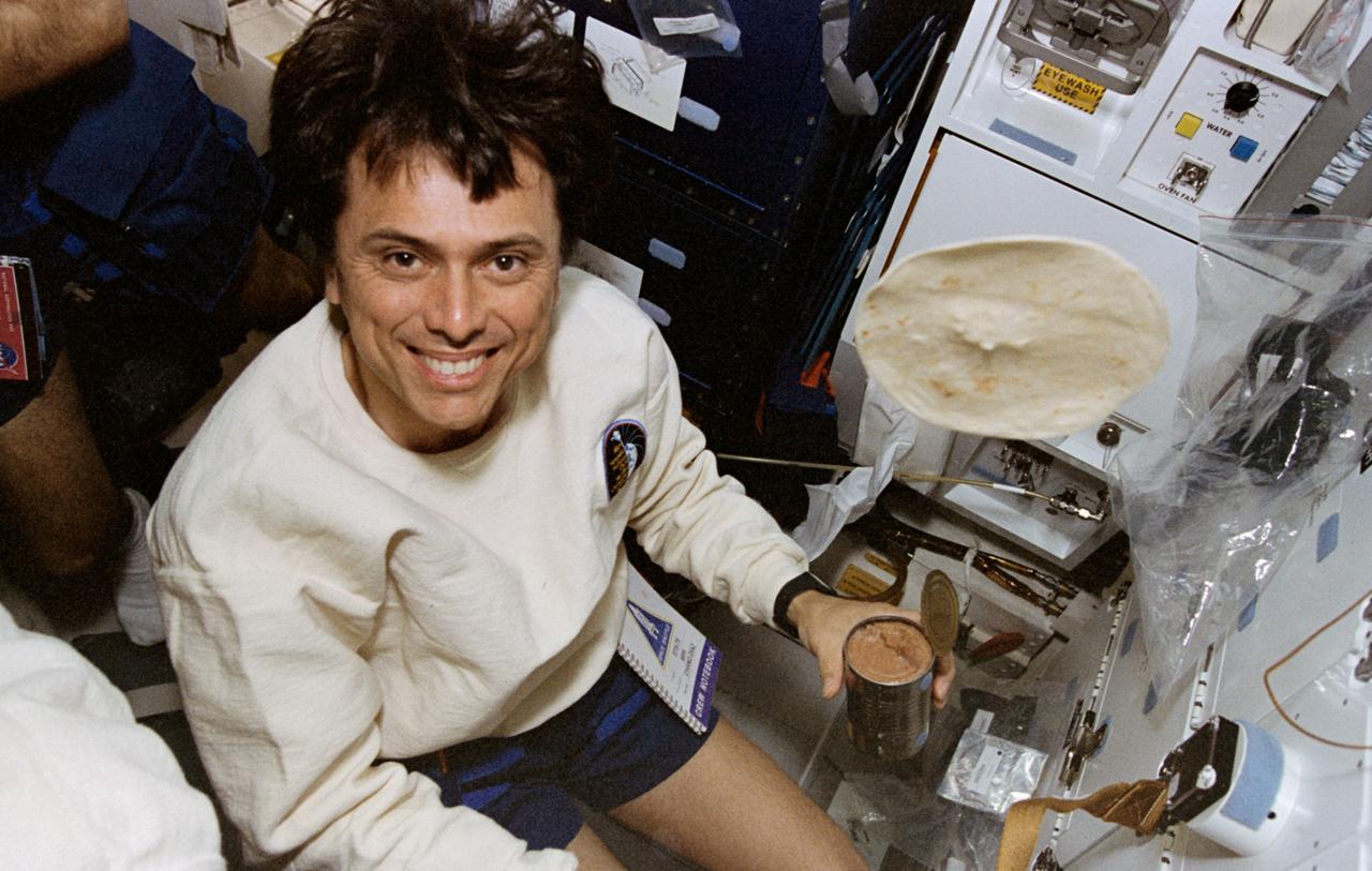 STS075-350-032 (22 Feb.-9 March 1996) --- Astronaut Franklin R. Chang-Diaz, STS-75 payload commander, is pictured with food items at the galley on the middeck of the Earth-orbiting space shuttle Columbia. Photo credit: NASA or National Aeronautics and Space Administration