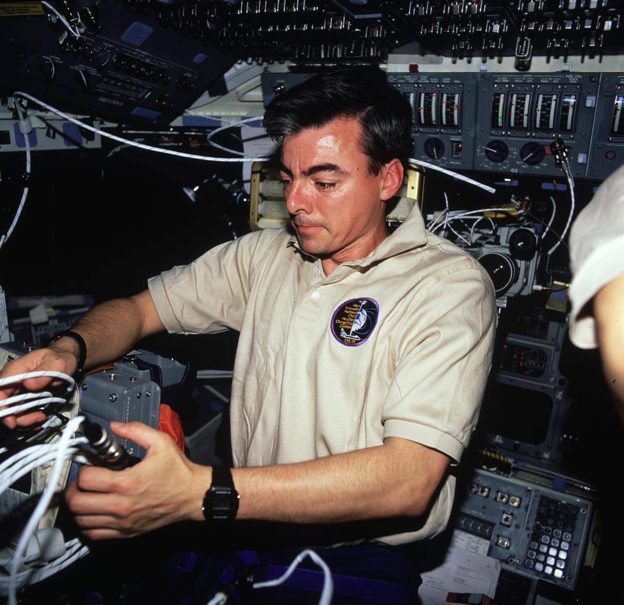 STS075-772-013 (22 Feb.- 9 March 1996) --- Astronaut Andrew M. Allen, mission commander, sets up systems for a television downlink on the flight deck of the space shuttle Columbia. Allen was joined by four other astronauts and an international payload specialist for more than 16 days of research aboard Columbia.  The photograph was taken with a 70mm handheld camera.