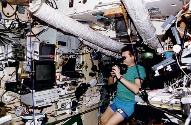 STS076-461-010 (22-31 March 1996) --- The STS-76 crew took this 70mm picture of Russia's Mir-21 mission commander Yury I. Onufrienko using a video camera on the Base Block Module of Russia's Mir Space Station.  The STS-76 crew docked the Space Shuttle Atlantis with the Mir Space Station on March 23, 1996, at which time astronaut Shannon W. Lucid (out of frame) joined Onufrienko and the mission's flight engineer, Yury V. Usachev, to begin the first leg of a 140-day stay aboard Mir, as a cosmonaut guest researcher.