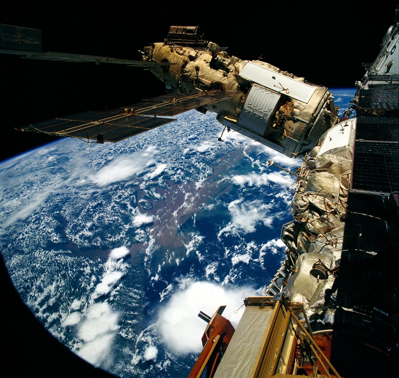 STS076-708-031 (22 - 31 March 1996) --- Clouds over Brazil form the backdrop for this 70mm image showing the Spektr Module and other components of Russia's Mir Space Station.  The photograph was taken after Space Shuttle Atlantis docked with the Mir Space Station on March 23, 1996.  The delta of the giant Amazon River is at frame center.