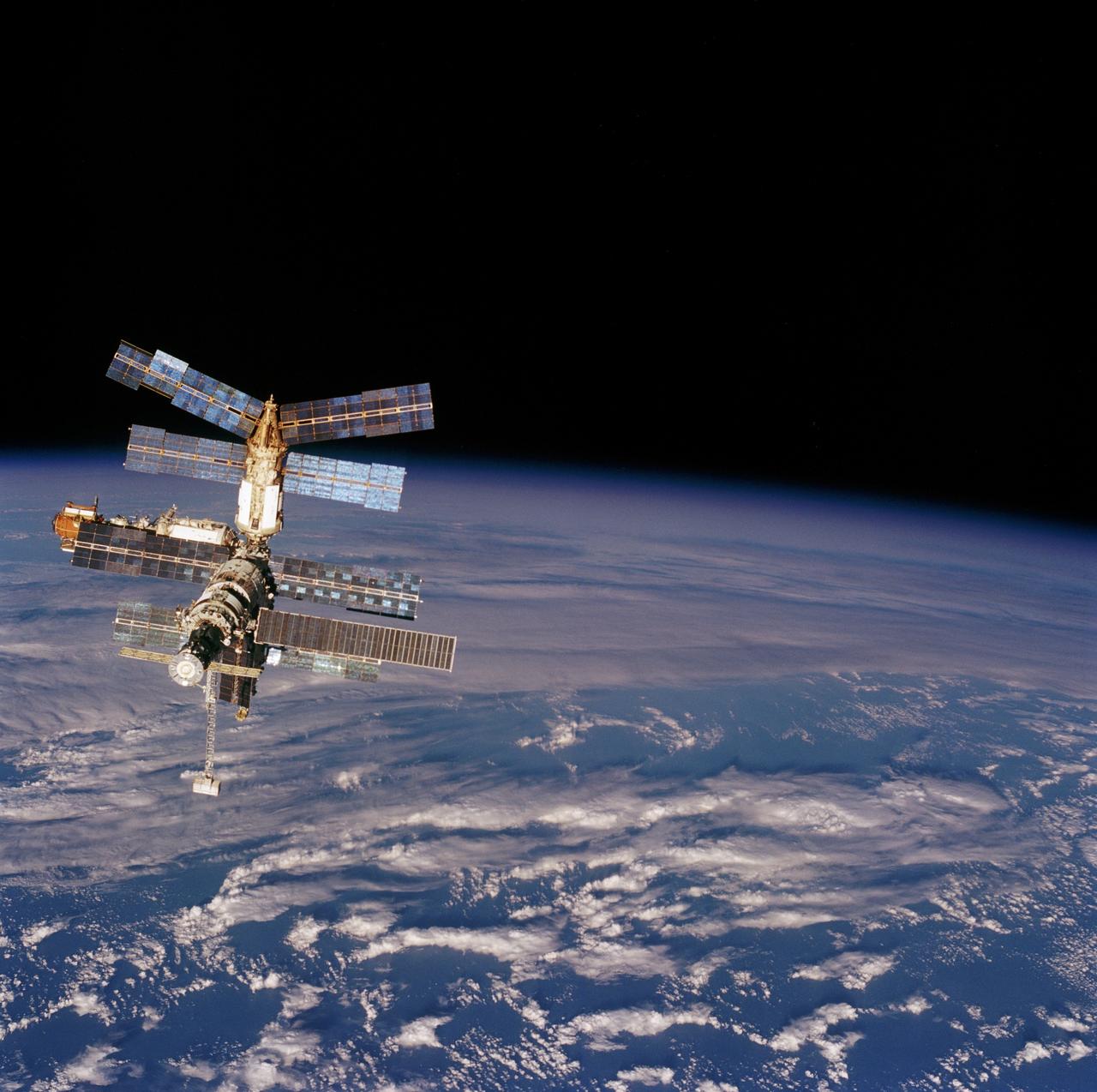 STS076-713-083 (23 March 1996) --- Backdropped against a massive array of clouds over the South Pacific Ocean and the Tasman Sea, Russia's Mir Space Station is seen from the aft flight deck of the Space Shuttle Atlantis.  The two spacecraft were in the process of making their third docking in Earth-orbit.  With the subsequent delivery of astronaut Shannon W. Lucid to the Mir, the Mir-21 crew grew to three, as the mission specialist quickly becomes a cosmonaut guest researcher.  She will spend approximately 140 days on Mir before returning to Earth.
