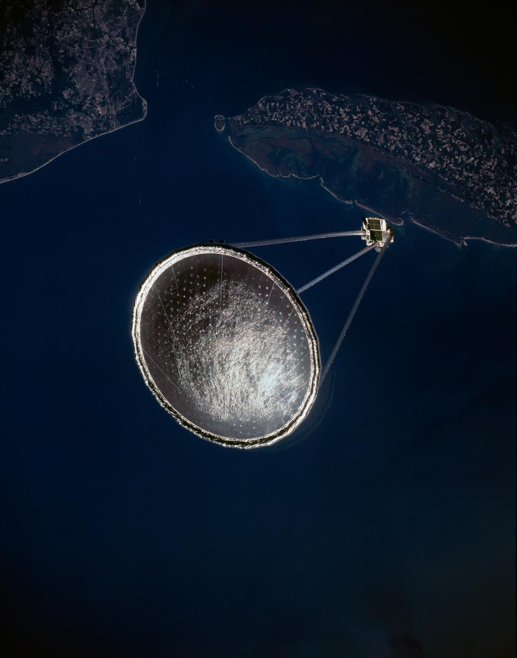 STS077-150-129 (20 May 1996) --- Following its deployment from the Space Shuttle Endeavour, the Spartan 207/Inflatable Antenna Experiment (IAE) payload is backdropped over the Atlantic Ocean and Hampton Roads, Virginia.  (Hold photograph vertically with land mass at top.)  Virginia Beach and part of Newport News can be delineated in the upper left quadrant of the frame.  The view was photographed with a large format still camera on the first full day of in-space operations by the six-member crew.  Managed by Goddard Space Flight Center (GSFC), Spartan is designed to provide short-duration, free-flight opportunities for a variety of scientific studies.  The Spartan configuration on this flight is unique in that the IAE is part of an additional separate unit which is ejected once the experiment is completed.  The IAE experiment will lay the groundwork for future technology development in inflatable space structures, which will be launched and then inflated like a balloon on-orbit.