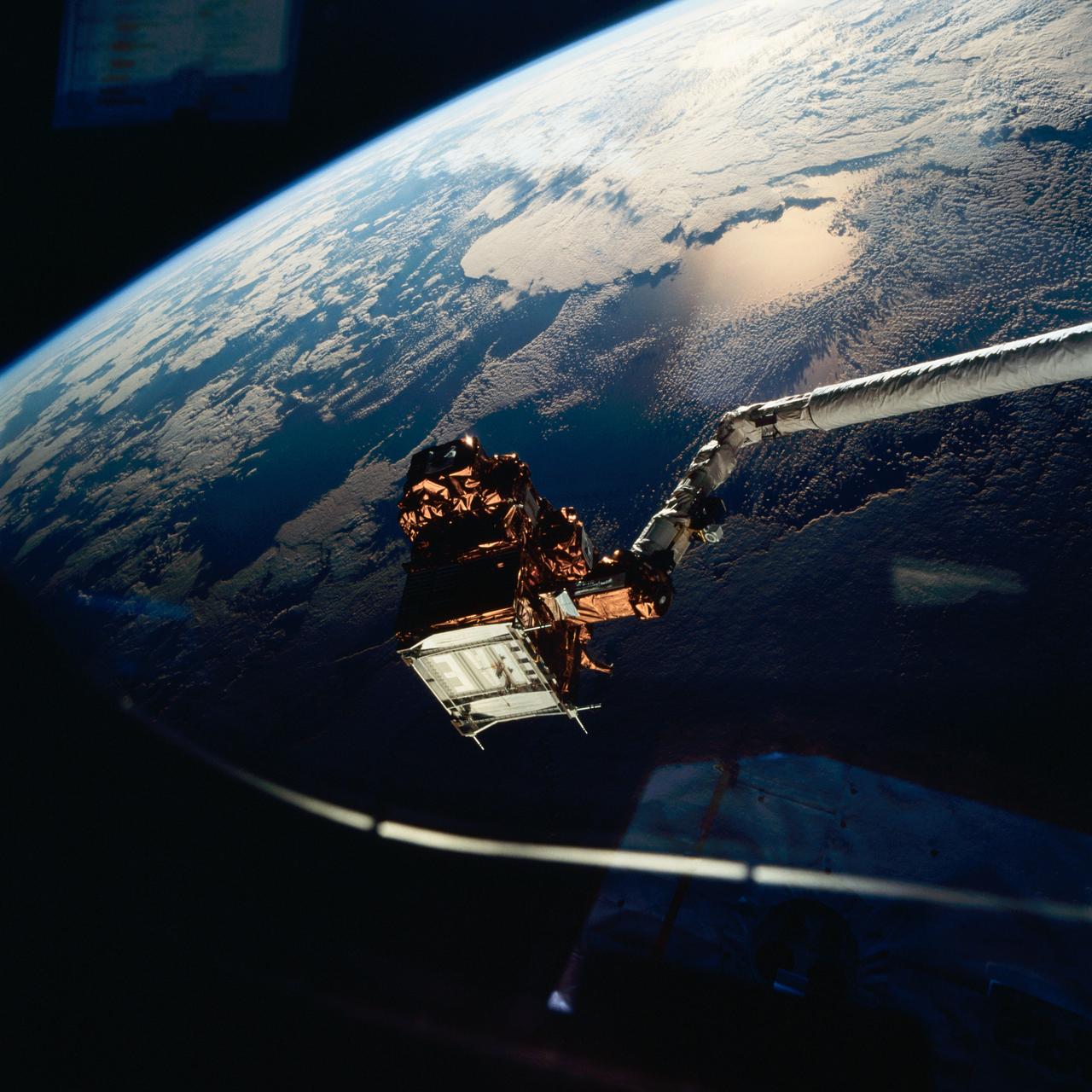 STS077-711-054 (21 May 1996) --- The Spartan 207 free flyer is held in the grasp of the Remote Manipulator System (RMS). As photographed through an overhead window on the Space Shuttle Endeavour?s aft flight deck, the satellite is backdropped against a heavily sunglinted horizon over the Middle East. The Spartan was re-captured by the six crew members on May 21, 1996 following a period of free-flight. The Endeavour crew spent a portion of the flight time in various activities involving the Spartan 207 and the related Inflatable Antenna Experiment (IAE). The Spartan project is managed by NASA?s Goddard Space Flight Center for NASA?s Office of Space Science, Washington, D.C.