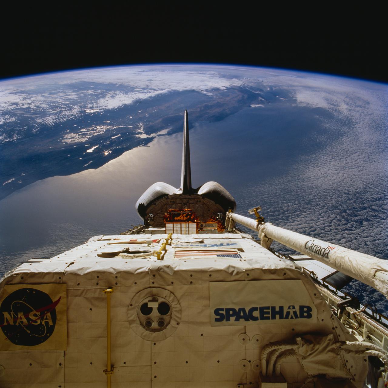 STS077-716-050 (19-29 May 1996) --- With part of the Pacific Ocean and almost the entire state of California as a backdrop, this scene of the Space Shuttle Endeavour’s cargo bay was photographed by a crew member on the aft flight deck.  Spacehab-4’s module is in the foreground, flanked by the Canadian-built Remote Manipulator System (RMS) arm and the Spartan-207 payload, both in stowed position.  Sunglint on the Earth scene accentuates the bay area of San Francisco.   The San Andreas Fault can also easily be traced not far inalnd from the coastline.
