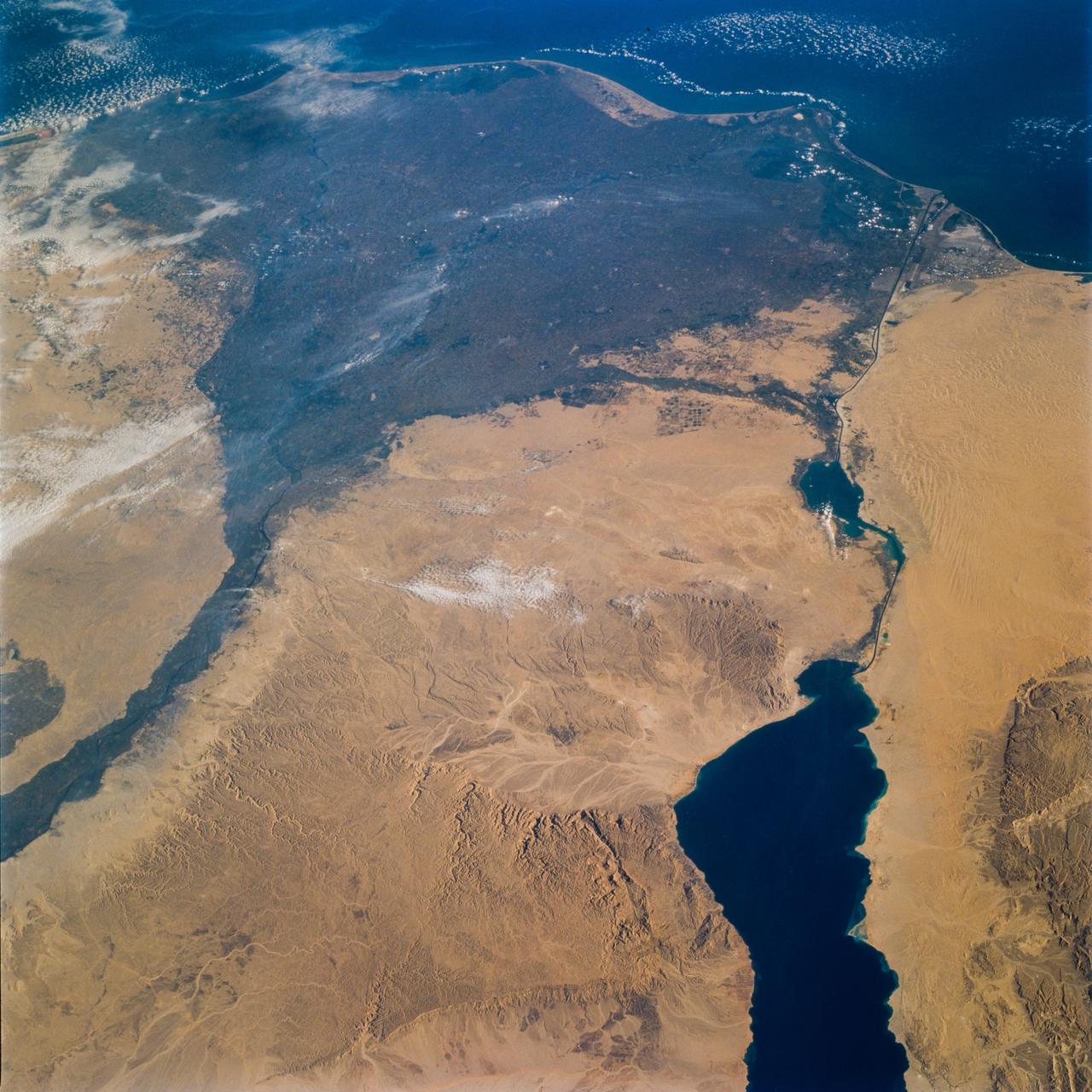 STS077-732-089 (19-29 May 1996) --- This photograph encompasses an area comprising 99 percent of the Egyptian population of close to 60 million people. North is roughly to the right side of the photograph. Cairo, the capital and principal city, lies at the apex of the Nile Delta. Alexandria is in the top right corner of the frame. The Suez Canal connects the Red Sea and the Mediterranean Sea and is in the bottom of the photograph. The Delta itself is 100 miles long and 160 miles wide at the coast. This view brings out the details of the Eastern Desert that rises abruptly from the Nile valley. This desert supports some vegetation in contrast to the sandier Western desert. It has more relief with some of the peaks rising to 6,000 feet. Rainfall in the region ranges from a high of 7 inches at Alexandria to 0.1 inch in the Eastern Desert. Most of Egypt’s mineral resources are concentrated in this area.
