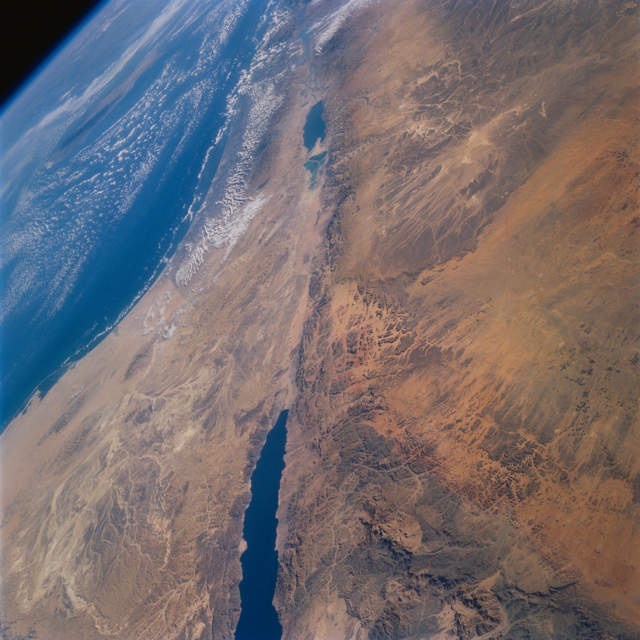 STS077-732-093 (19-29 May 1996) --- This high oblique perspective from the Space Shuttle Endeavour shows the Dead Sea Rift Valley and the surrounding deserts.  North is to the right side of the frame.  The vegetation line on the coast between Egypt and Israel is clearly visible.  Crete is visible in the Mediterranean Sea.  The Dead Sea was formed approximately 3 million years ago.  A passage opened up to the sea and the water poured in.  It is about 1,300 feet below sea level.  It is fed by the Jordan River and numerous mineral springs from the surrounding hills.  It is estimated to contain 43 million metric tons of salt.  The salinity is 32 percent.
