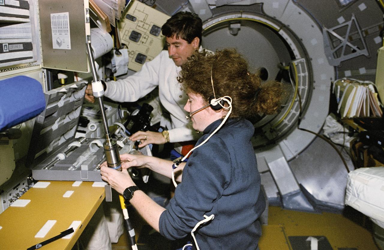 STS078-368-022 (20 June - 7 July 1996) --- Astronauts Susan J. Helms, payload commander, and Terence T. (Tom) Henricks, mission commander, prepare a sample cartridge containing semiconductor crystals for Spacelab research. The crystals were later placed in the Advanced Gradient Heating Furnace (AGHF) in the Life and Microgravity Spacelab (LMS-1) Science Module. The AGHF is designed for directional solidification of the crystals in the sample cartridges. The microgravity of space allows the crystals to grow in a perfect state that can not be accomplished in Earth's gravity.