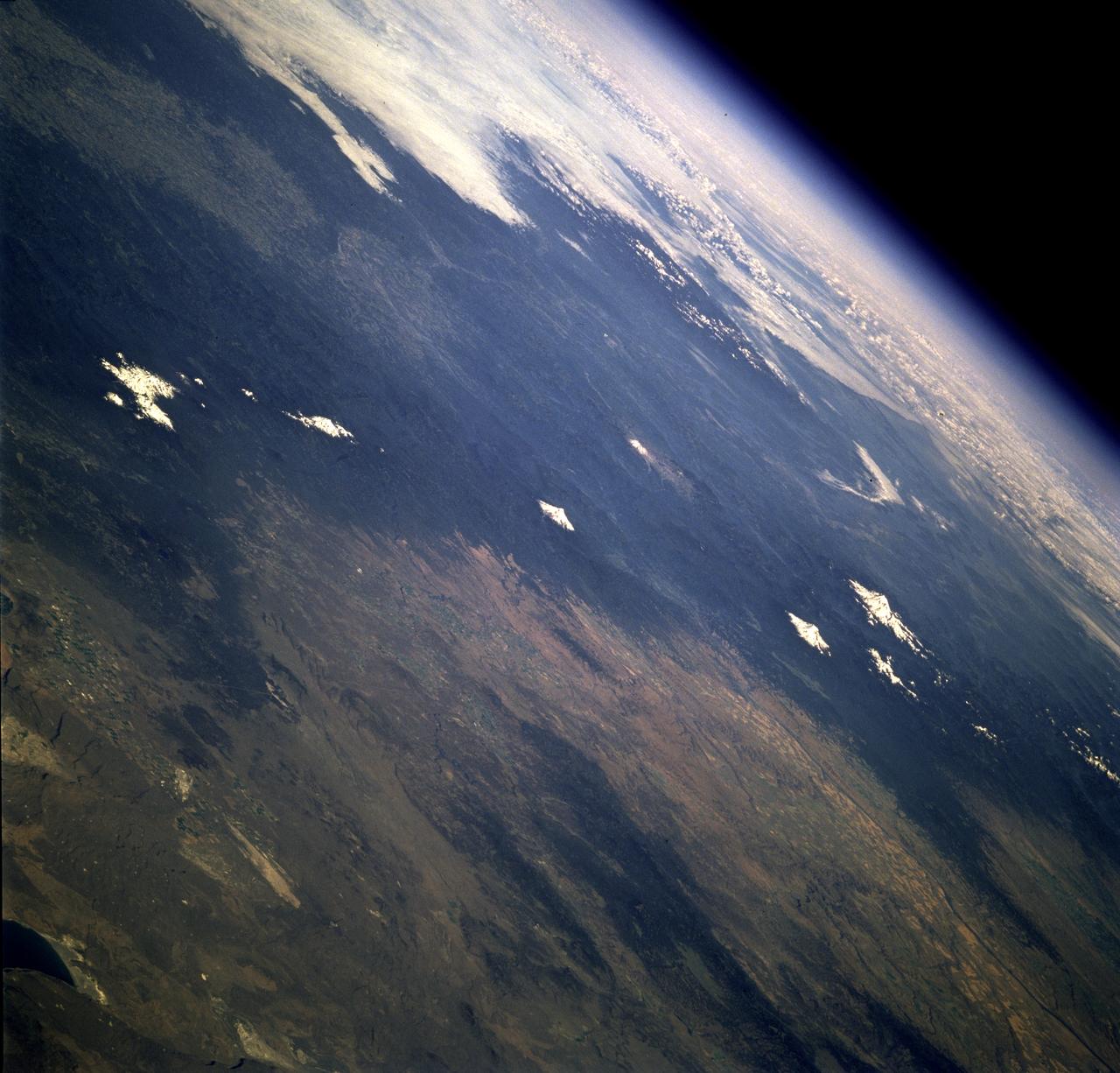 STS078-742-004 (20 June - 7 July 1996) --- This is a north-looking perspective of the major volcanoes of the Cascade Mountains of southern Washington and northern Oregon. With the Earth limb in the upper left corner of the photo, the large mountain at the top right, or northern part of the photo, is Mt. Rainier. The next snow covered area to the south east of Mt. Rainier is Gilbert Point. Mt. Adams is the larger peak, south-southeast of Mt. Rainier, Mt. St. Helens is the gray patch in the center of the photo, west of Mt. Adams. Mt. St. Helens erupted on May 18, 1980, removing 1,300 feet of the 9,677-ft. volcano. The eruption toppled trees with a searing, stone-filled 275-mile-per-hour wind over an area of more than 150 square miles. This area, now referred to as the "blast zone", can be easily spotted in this view. NASA scientists say that natural regrowth of vegetation within the blast zone is progressing at a rapid rate, especially on the outer fringes and in the protected valleys. Many fir trees have grown to heights exceeding 20 feet in a little over 12 years. A large lava dome within the crater of the volcano has grown to a height of over 1,000 feet since the 1980 eruption. The next three snow covered peaks are Mt. Hood, Mt. Jefferson and the Three Sisters all located in Oregon.