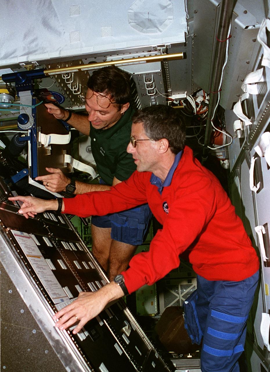 STS079-302-006 (16-26 Sept. 1996) --- Astronauts Jerome (Jay) Apt (right) and Carl E. Walz, both mission specialists, tilt the Active Rack Isolation System (ARIS) hardware which was included on this flight to evaluate conditions and hardware requirements for the International Space Station (ISS). The ARIS is designed to isolate certain experiments from major disturbances that are expected to be found on the ISS, such as vibrations caused by the movement of mechanisms and crew members and the operation of equipment. STS-79 was chosen for the inclusion of the experiment because the Shuttle-Mir complex more closely approximates the acceleration environment of the ISS.