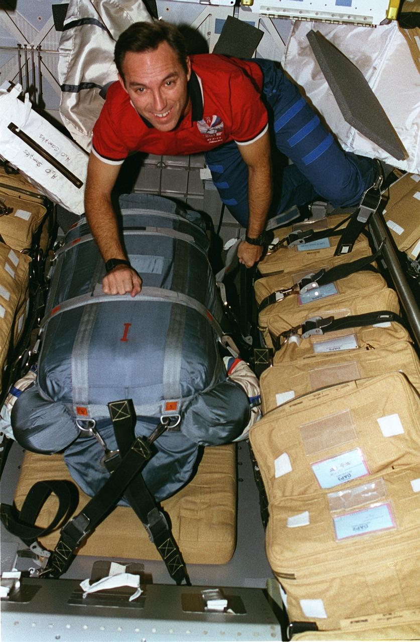 STS079-304-001 (16 Sept. 1996)--- Astronaut Carl E. Walz totes a bag carrying a space suit used by the cosmonauts.  At the completion of the STS-79 mission, the suit was brought back to Earth for analysis.  This photograph is one of fifteen 35mm frames (along with four 70mm frames) of still photography documenting the activities of NASA's STS-79 mission, which began with a September 16, 1996, liftoff from Launch Pad 39A the Kennedy Space Center (KSC) and ended with a landing at KSC on September 26, 1996.  Onboard for the launch were astronauts William F. Readdy, commander; Terrence W. Wilcutt, pilot; John E. Blaha, Jerome (Jay) Apt, Thomas D. Akers and Walz, all mission specialists.  On flight day 4, the crew docked with Russia's Mir Space Station.  Shannon W. Lucid, who had spent six months aboard Mir, switched cosmonaut guest researcher roles with Blaha.  The latter joined fellow Mir-22 crew members Valeri G. Korzun, commander, and Aleksandr Y. Kaleri, flight engineer.