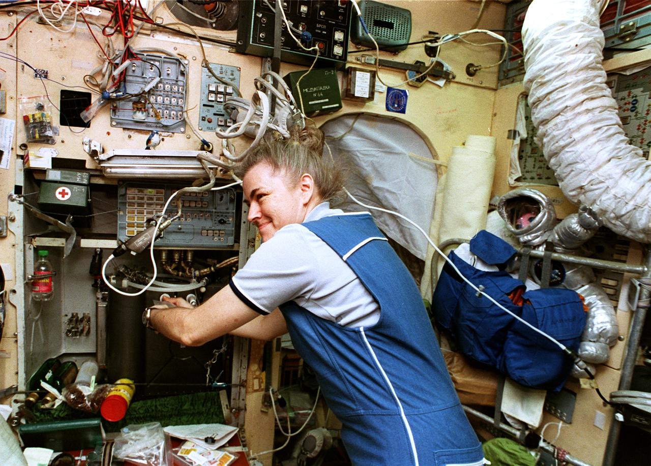 STS079-354-001 (16-26 Sept. 1996) --- Astronaut Shannon W. Lucid gets a beverage at the galley on Russia's Mir Space Station Base Block.  This photograph is one of fifteen 35mm frames (along with four 70mm frames) of still photography documenting the activities of NASA's STS-79 mission, which began with a September 16, 1996, liftoff from Launch Pad 39A the Kennedy Space Center (KSC) and ended with a landing at KSC on September 26, 1996.  Onboard for the launch were astronauts William F. Readdy, commander; Terrence W. Wilcutt, pilot; John E. Blaha, Jerome (Jay) Apt, Thomas D. Akers and Carl E. Walz, all mission specialists.  On flight day 4, the crew docked with Mir.  Lucid, who had spent six months aboard Mir, switched cosmonaut guest researcher roles with Blaha.  The latter joined fellow Mir-22 crew members Valeri G. Korzun, commander, and Aleksandr Y. Kaleri, flight engineer.