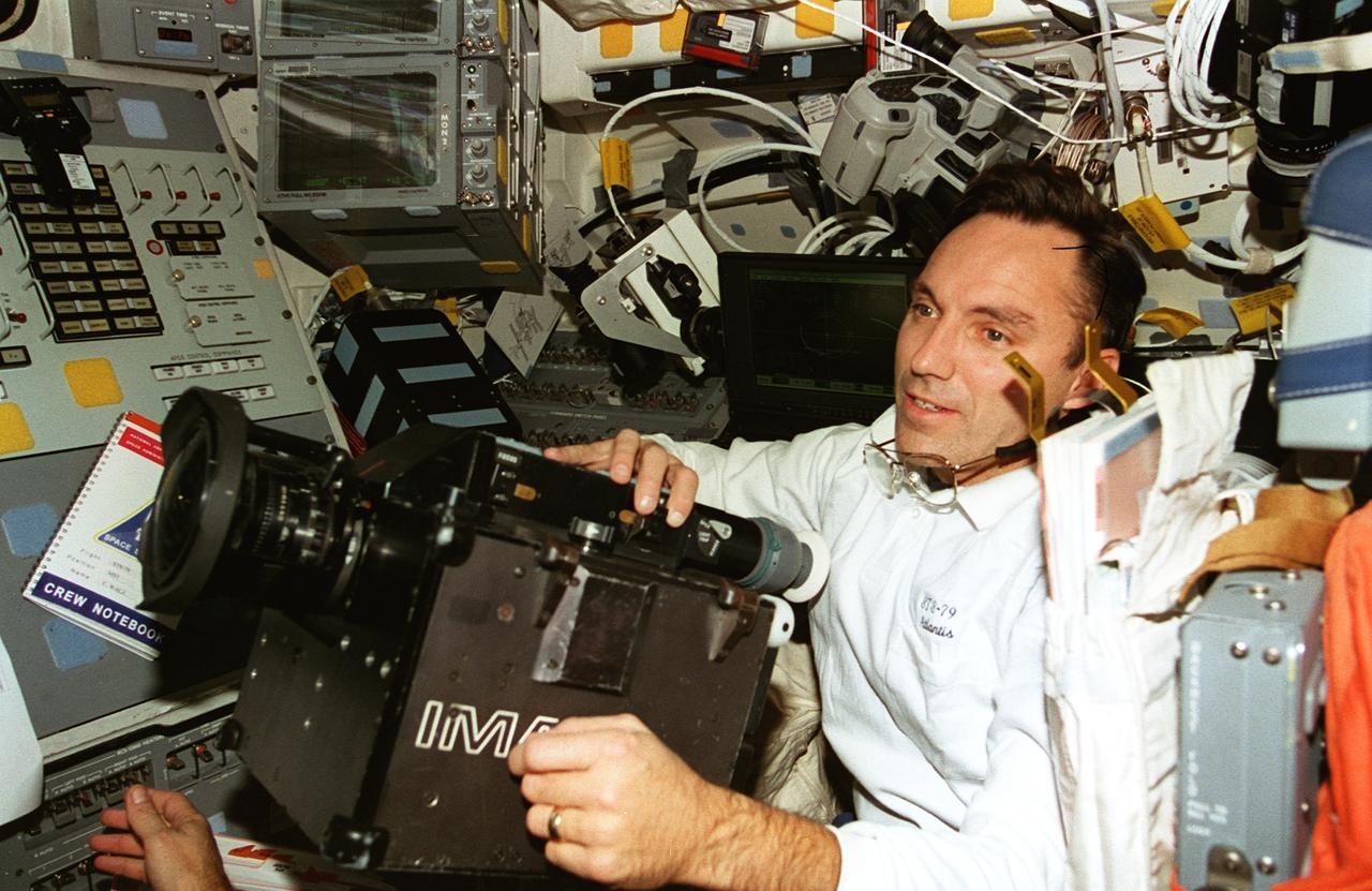 STS079-362-023 (16-26 Sept. 1996) --- Astronaut Carl E. Walz, mission specialist, positions the IMAX camera for a shoot on the flight deck of the Space Shuttle Atlantis.  The IMAX project is a collaboration among NASA, the Smithsonian Institution's National Air and Space Museum, IMAX Systems Corporation and the Lockheed Corporation to document in motion picture format significant space activities and promote NASA's educational goals using the IMAX film medium.  This system, developed by IMAX of Toronto, uses specially designed 65mm cameras and projectors to record and display very high definition color motion pictures which, accompanied by six-channel high fidelity sound, are displayed on screens in IMAX and OMNIMAX theaters that are up to ten times larger than a conventional screen, producing a feeling of "being there."  The 65mm photography is transferred to 70mm motion picture films for showing in IMAX theaters.  IMAX cameras have been flown on 14 previous missions.