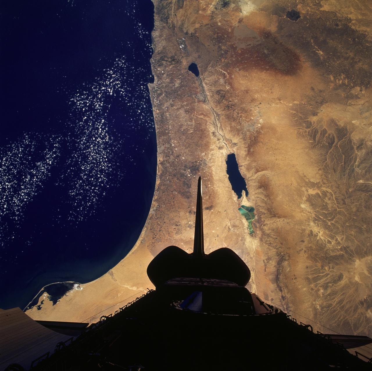 STS079-824-081 (16-26 Sept. 1996) --- In this 70mm frame from the space shuttle Atlantis, the Jordan River Valley can be traced as it separates Lebanon, Palestine and Israel on the west, from Syria and Jordan on the east. The river flows along the Dead Sea rift; the east side of the fault zone (Syria, Jordan, Saudi Arabia) has moved north about 100 kilometers relative to the west side (Lebanon, Israel, Egypt) during the past 24 million years. The Dead Sea and Sea of Galilee are in depressions formed where faults of the zone diverge or step over.  The Dead Sea once covered the area of salt evaporation pans (the bright blue water). The lagoon, barrier islands and evaporite deposits (bright white) along the Mediterranean coast of the Sinai Peninsula (lower left of frame) are just east of Port Said.