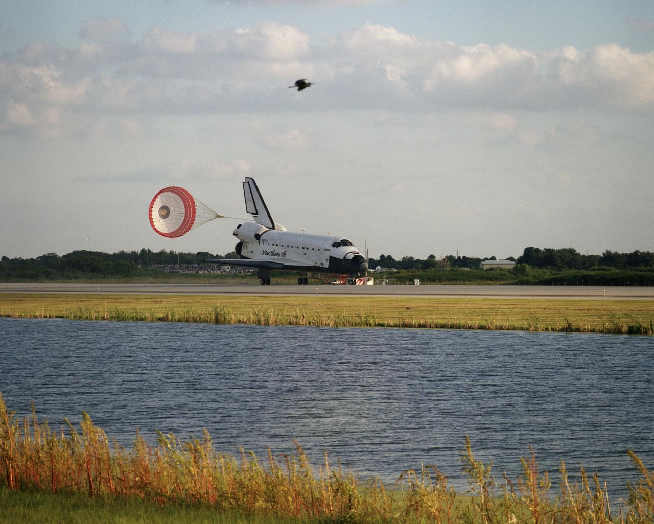 STS079-S-021 (26 Sept. 1996) --- The drag chute on the space shuttle Atlantis is fully deployed as the orbiter rolls down Runway 15 at the Shuttle Landing Facility (SLF) at the Kennedy Space Center (KSC), bringing an end to the successful ten-day mission. Landing occurred at 8:13:15 a.m. (EDT), Sept. 26, 1996. The touchdown marked the end of 188 days in space for astronaut Shannon W. Lucid, following her in-space exchange with astronaut John E. Blaha, who is now aboard Russia's Mir Space Station. Returning along with Lucid were her STS-79 crew mates - astronauts William F. Readdy, commander; Terrence W. Wilcutt, pilot; and Thomas D. Akers, Jerome (Jay) Apt and Carl E. Walz, mission specialists.