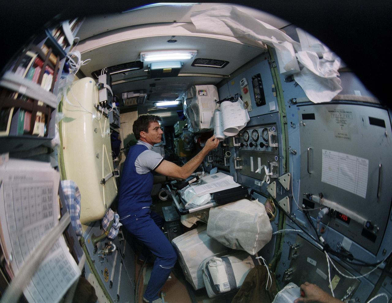 STS079-S-062 (16-26 Sept. 1996) --- Astronaut John E. Blaha, here serving as a cosmonaut guest researcher onboard Russia's Mir Space Station, is pictured on the Spektr Module during his "move" from the Space Shuttle Atlantis. During the STS-79 mission, the crew used an IMAX camera to document activities aboard the space shuttle Atlantis and the various Mir modules. A hand-held version of the 65mm camera system accompanied the STS-79 crew into space in Atlantis' crew cabin. NASA has flown IMAX camera systems on many shuttle missions, including a special cargo bay camera's coverage of other recent Shuttle-Mir rendezvous and/or docking missions.