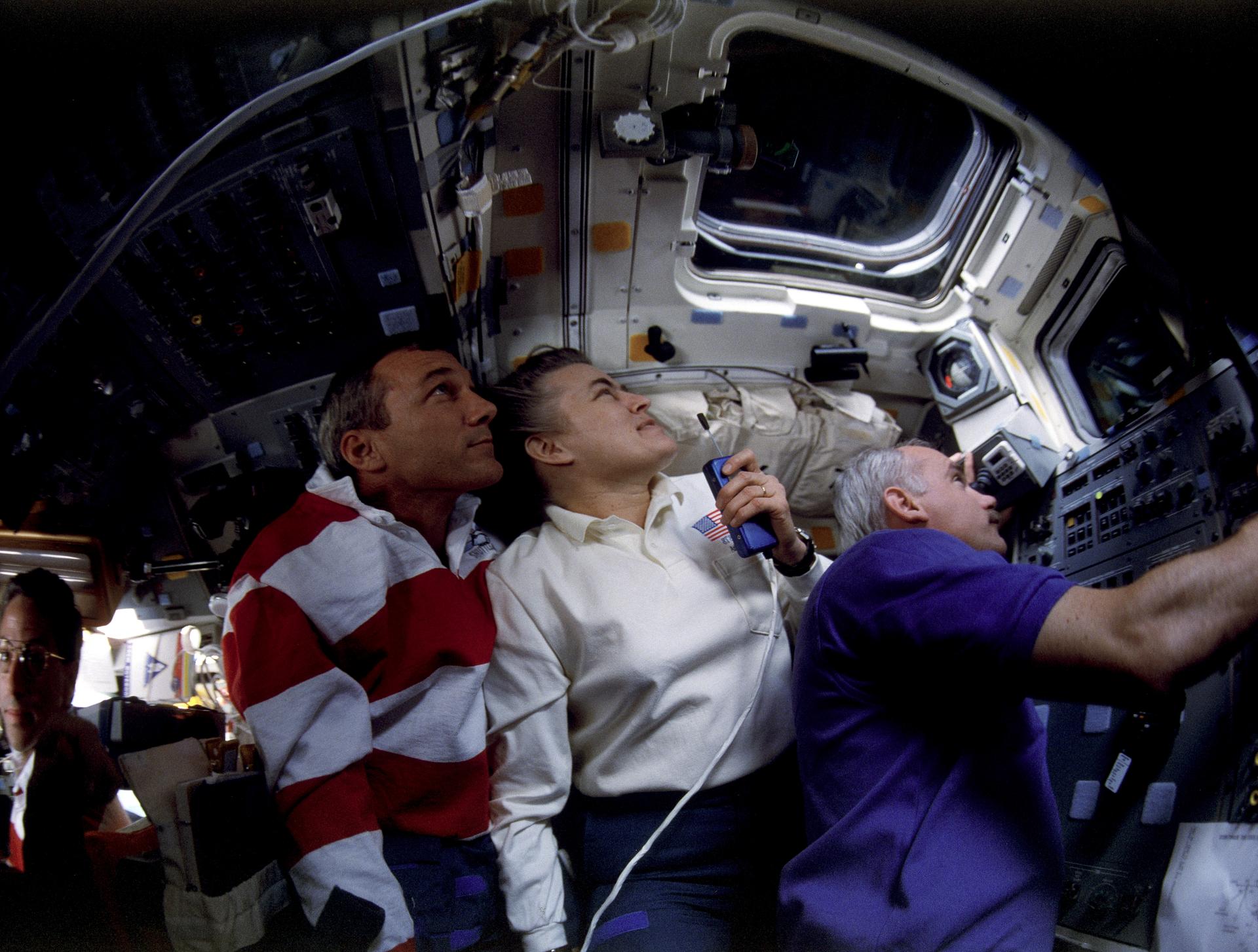 STS-79 crew watches from aft flight deck during undocking from Mir