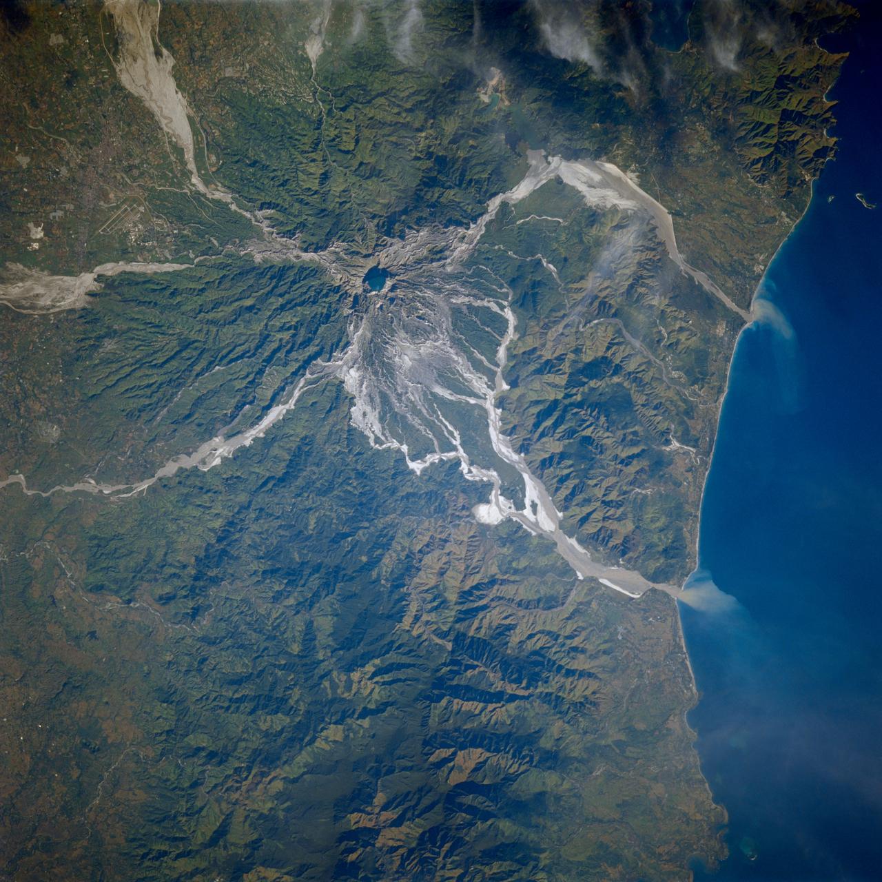 STS080-706-044 (19 Nov.-7 Dec. 1996) --- This view shows Mount Pinatubo, an active volcano in the Zambales Mountains range of western Luzon, the main island of the Philippines. Mud flows radiate out from the active volcano, which has erupted in recent years, coming down the mountain. After the eruption a lot of the vegetation was removed, causing the mountain to erode at a more rapid pace than an older mountain that has its vegetation in place. In two cases the flows reach the South China Sea, and flow down three valleys to the east. The now abandoned Clark Air Force Base is to the upper left corner. Pinatubo is about 80 miles northwest of Manila.